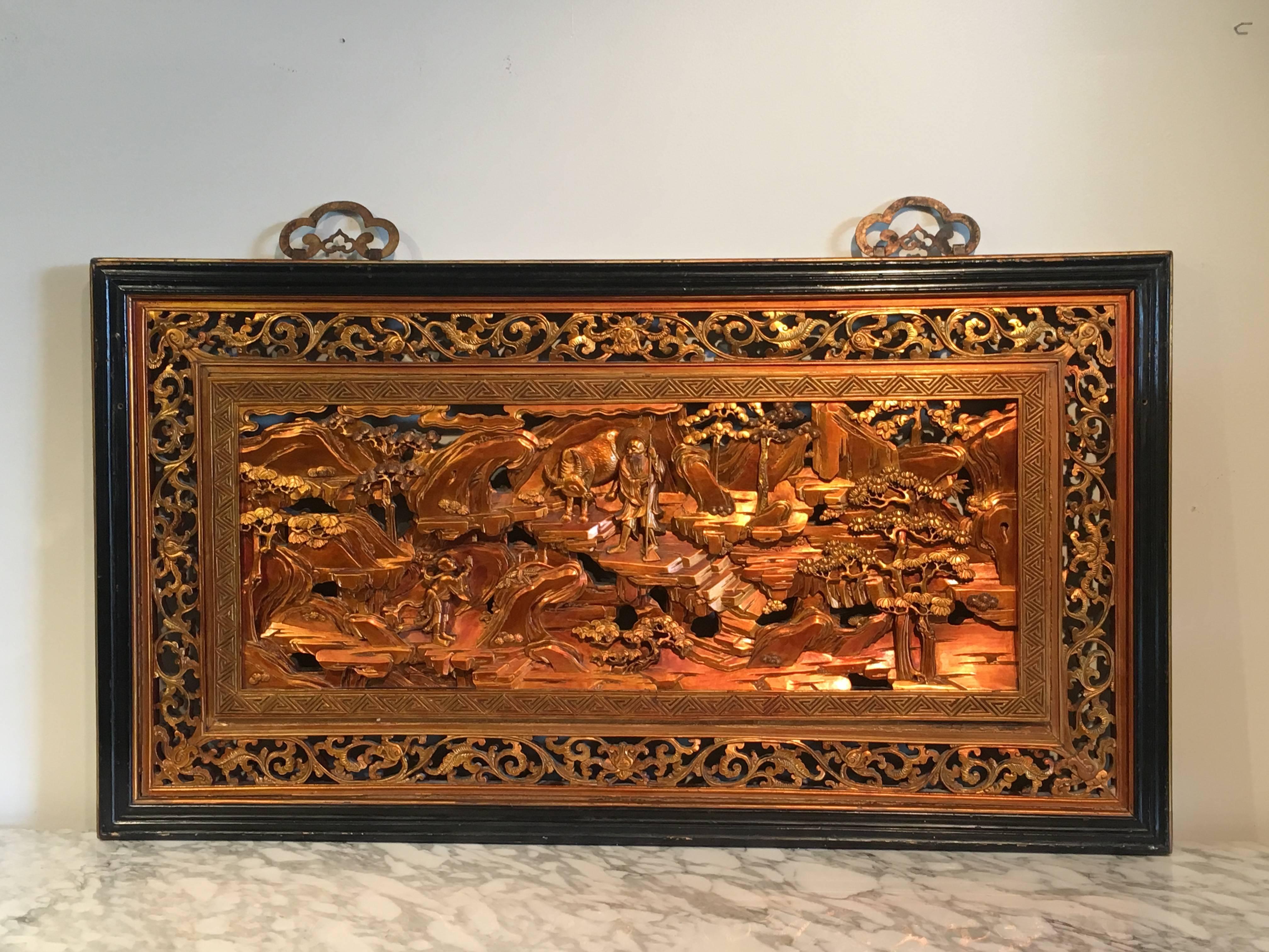 A very rare Qing dynasty Southern Chinese carved and pierced lacquered hardwood panel featuring a double sided scene, 19th century.
The front scene of Buddhist monks and scholars in an idyllic garden setting. The standing figure appears to be