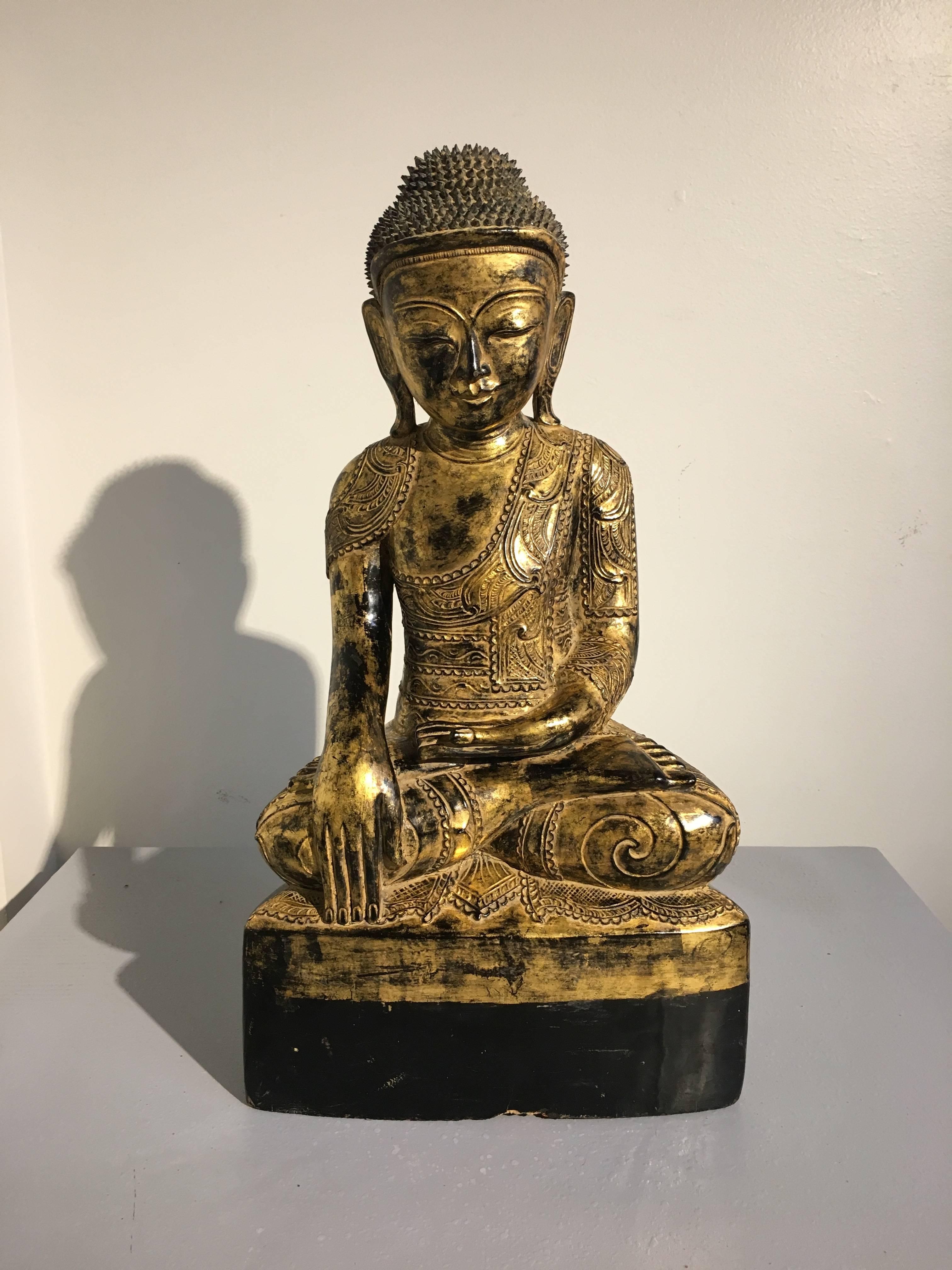 A sublime and rare late 18th century Burmese Ava period carved, lacquered and gilt Buddha. The historical Buddha, Shakyamuni, is portrayed in bhumisparsha mudra, the gesture of calling the Earth to witness, commemorating the moment the Buddha