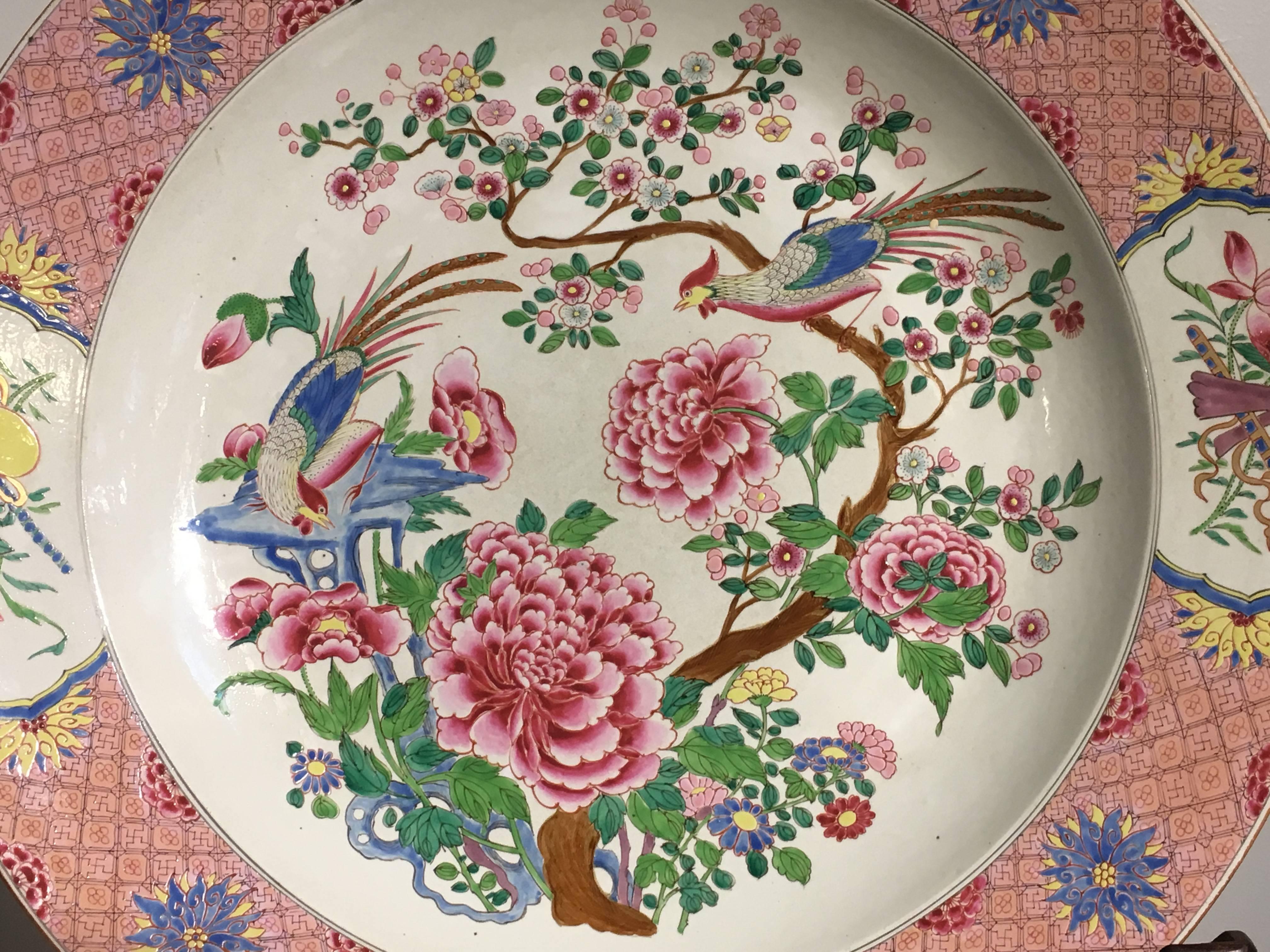 A massive famille rose enameled Chinese export style charger, Continental, probably French, circa 1900.

The large dish painted in vibrant famille rose enamels in an overall pink tone, with a central design of a pair of long tailed birds perched