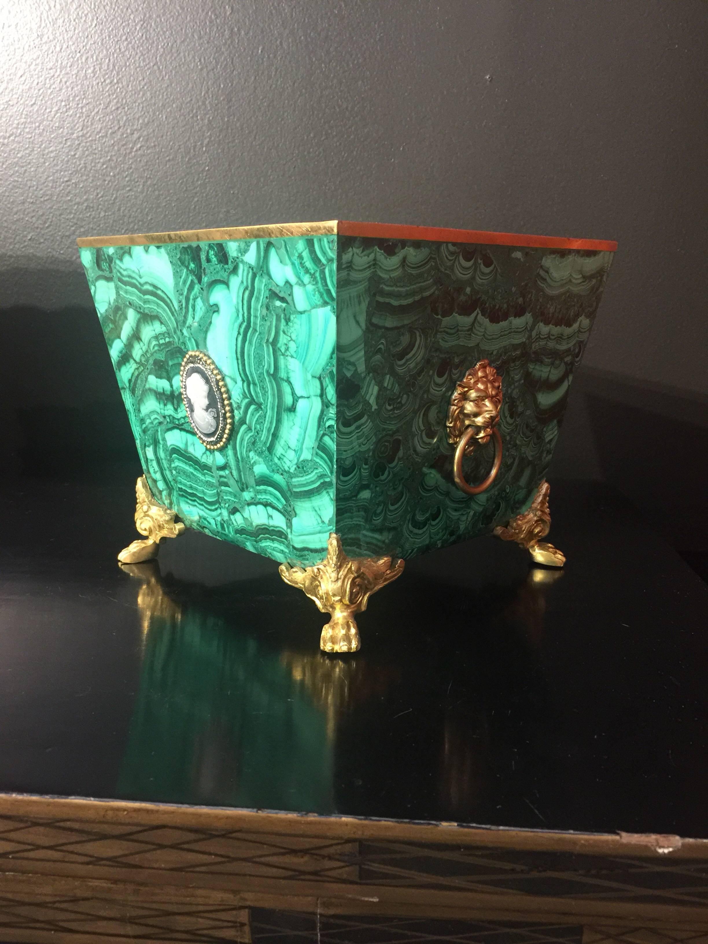 A pair of solid malachite jardinière adorned with gilt bronze feet, top borders and handles in square form. There are 
