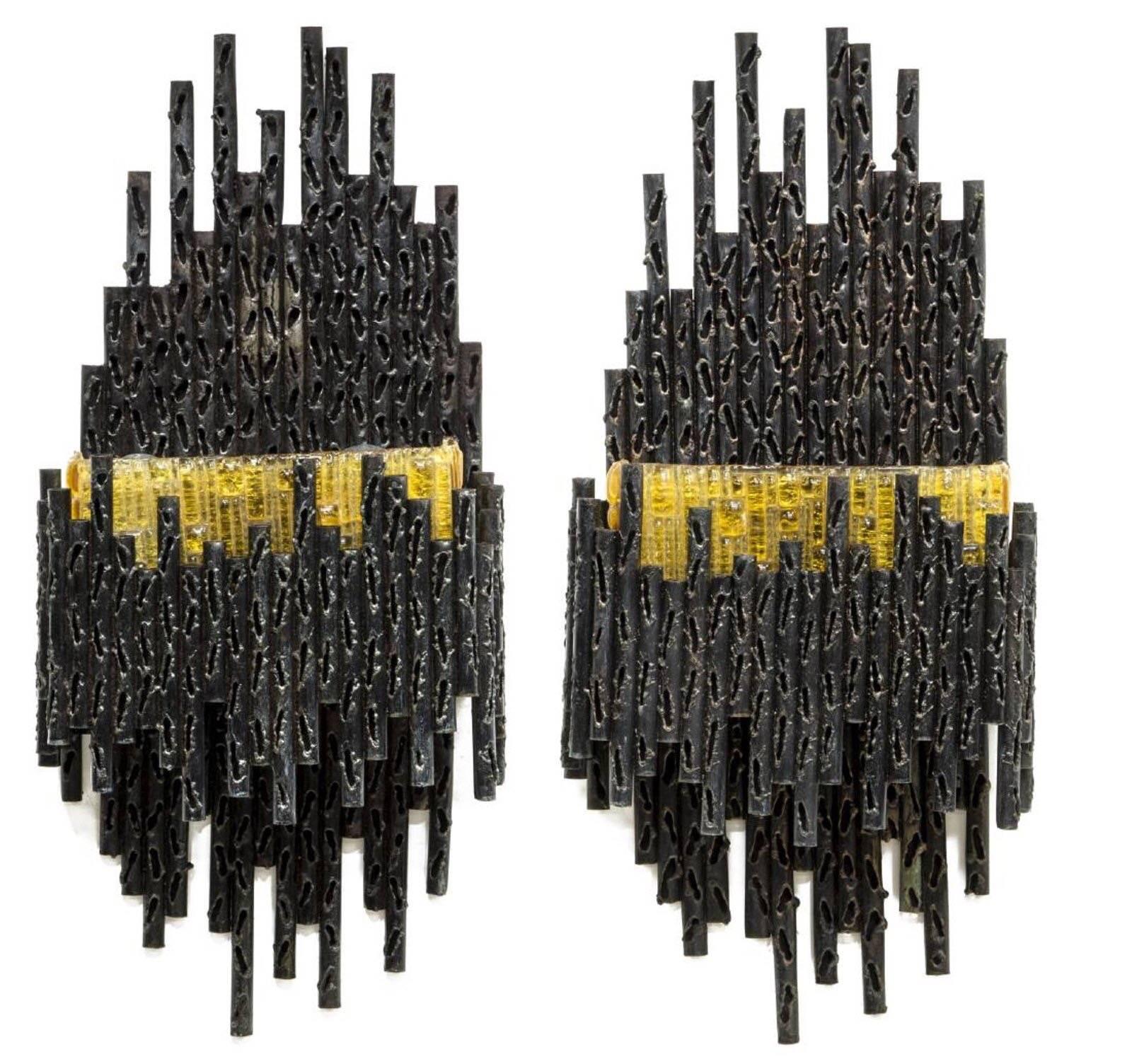 Pair of impressive and rare brutalist two lights sconces designed by Marcello Fantoni, circa 1970s.  

The large sconces crafted of patinated, tubular forms of various sizes. Fitted with beautiful textured golden color Murano glass shades to cover