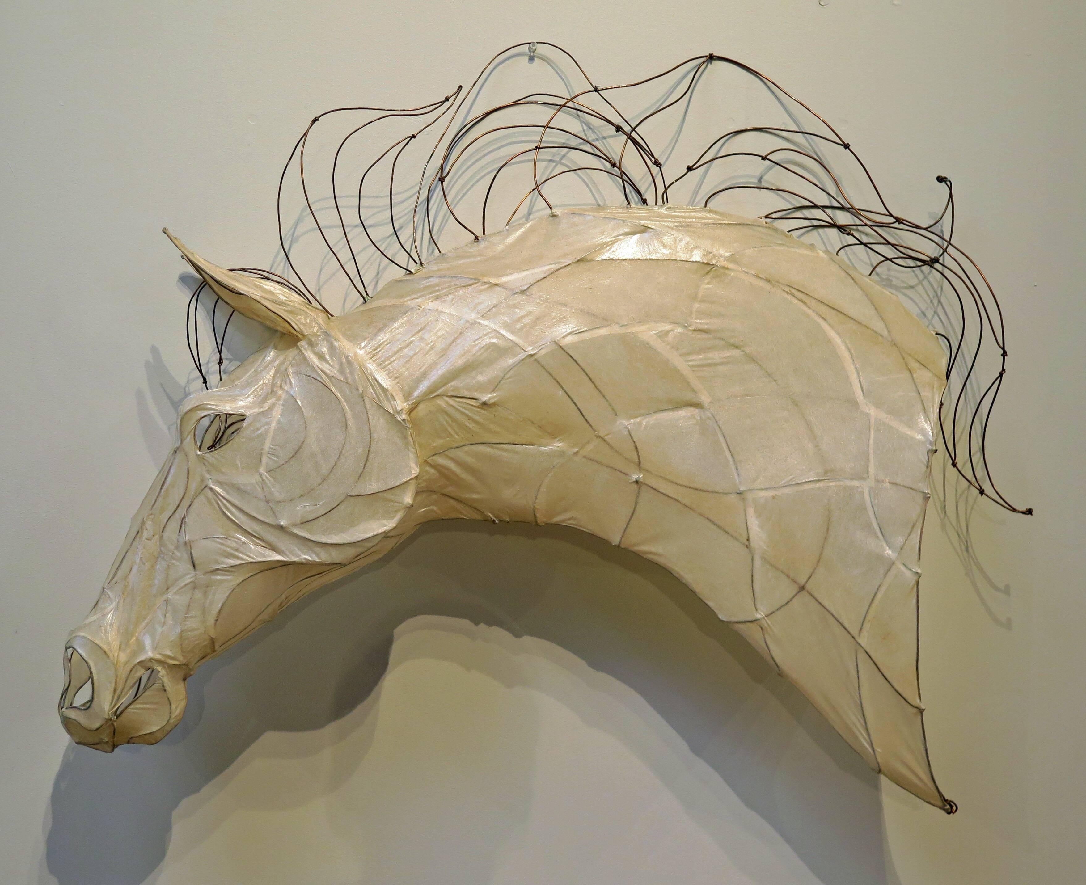 A stunning near life-sized sculpture of a horse head. Crafted from a translucent glazed white paper over a copper wire frame, the mane also of copper wire, bent and twisted, as if being blown by the wind.
Reminiscent of Inuit seal gut parkas and