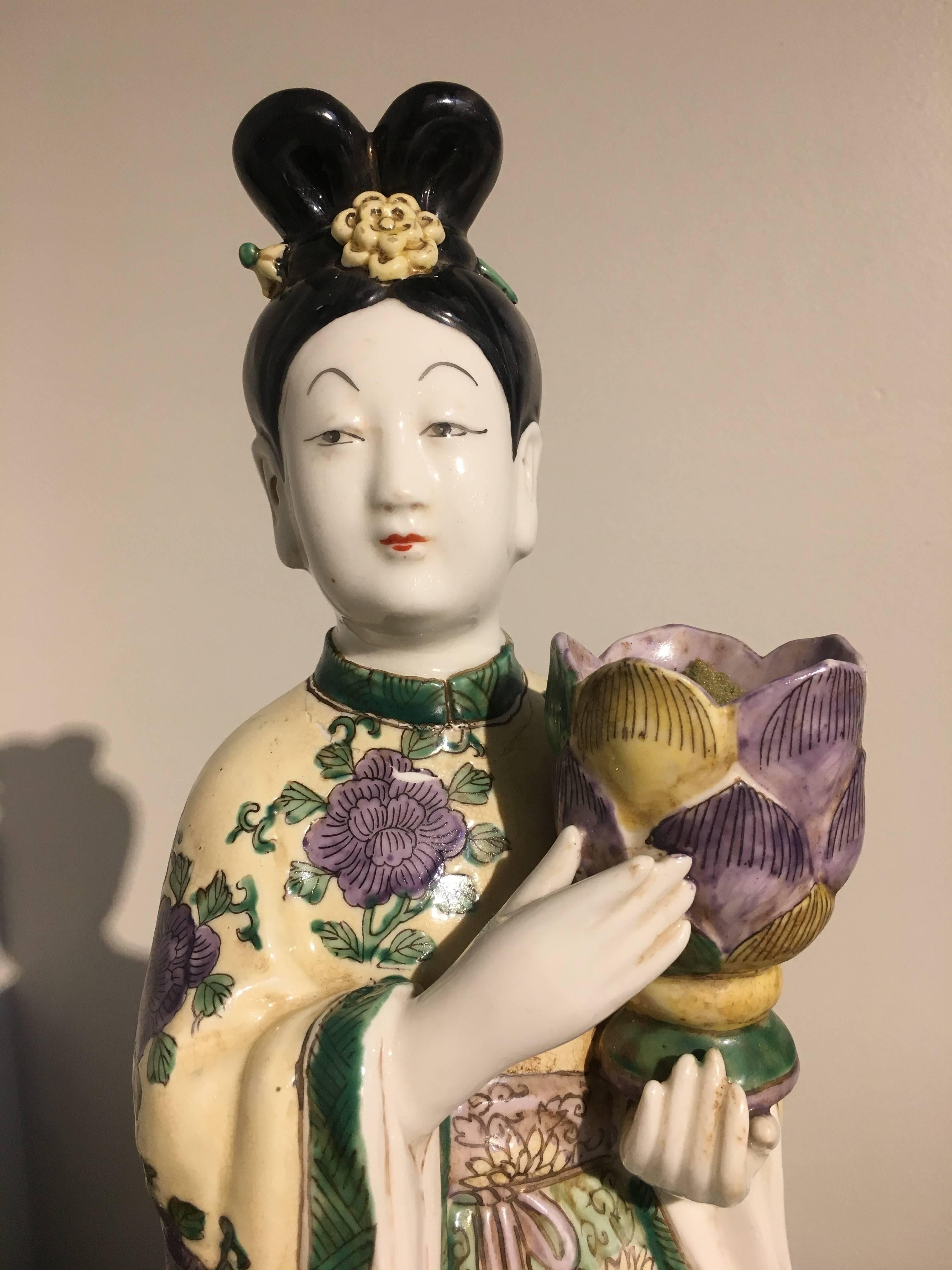 Une belle paire de bougeoirs en porcelaine d'exportation chinoise en forme de dames de cour tenant des fleurs de lotus, milieu du 20e siècle, vers les années 1960, Chine.

Inspirées des modèles Qianlong du XVIIIe siècle, ces dames raffinées sont