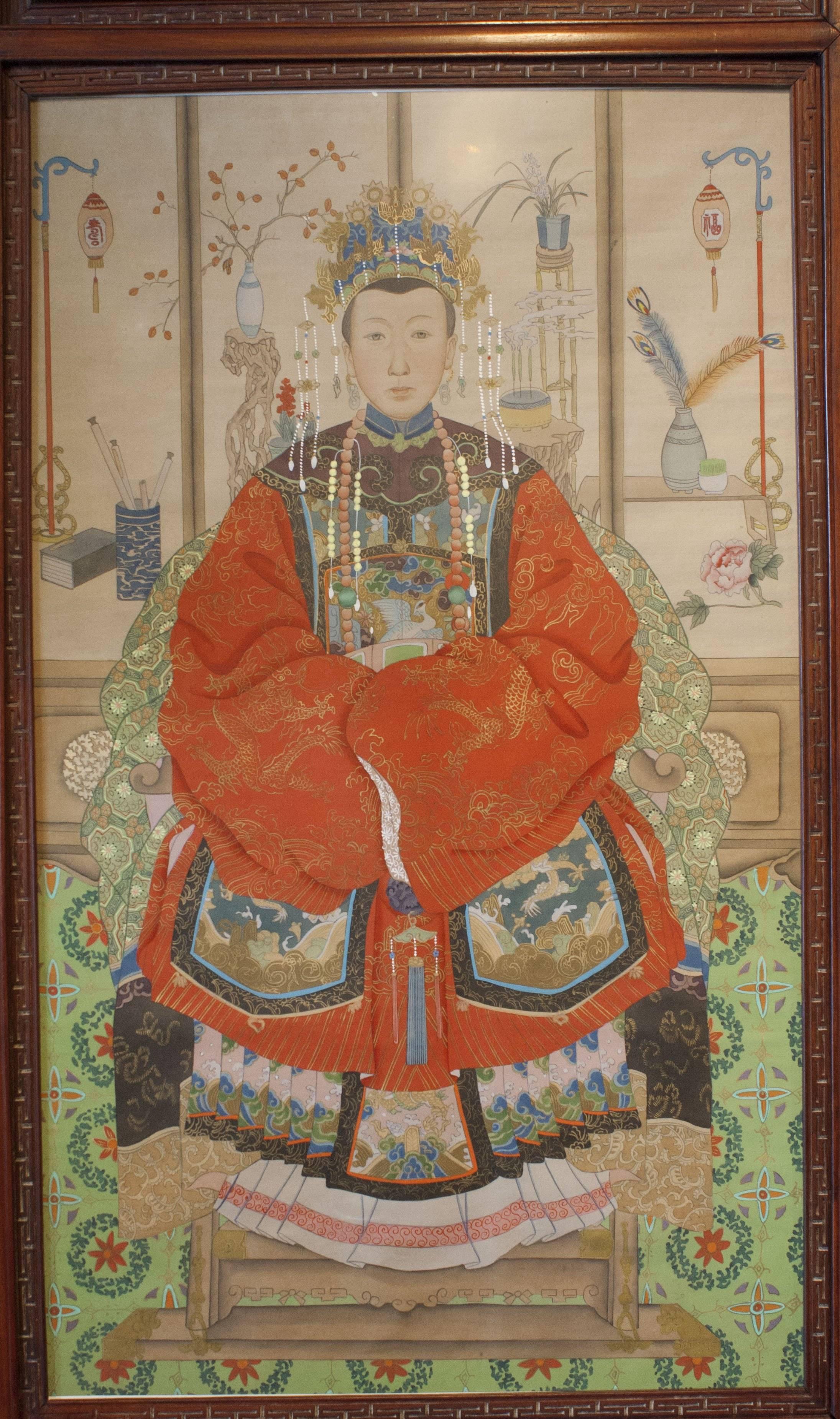 A pair of hand painted ancestor portraits in carved rosewood frames, with reverse glass painted accents.

Painted during China's Republic Period (1912-1949), the portraits are portrayals of members of the Qing Dynasty Imperial court in their full