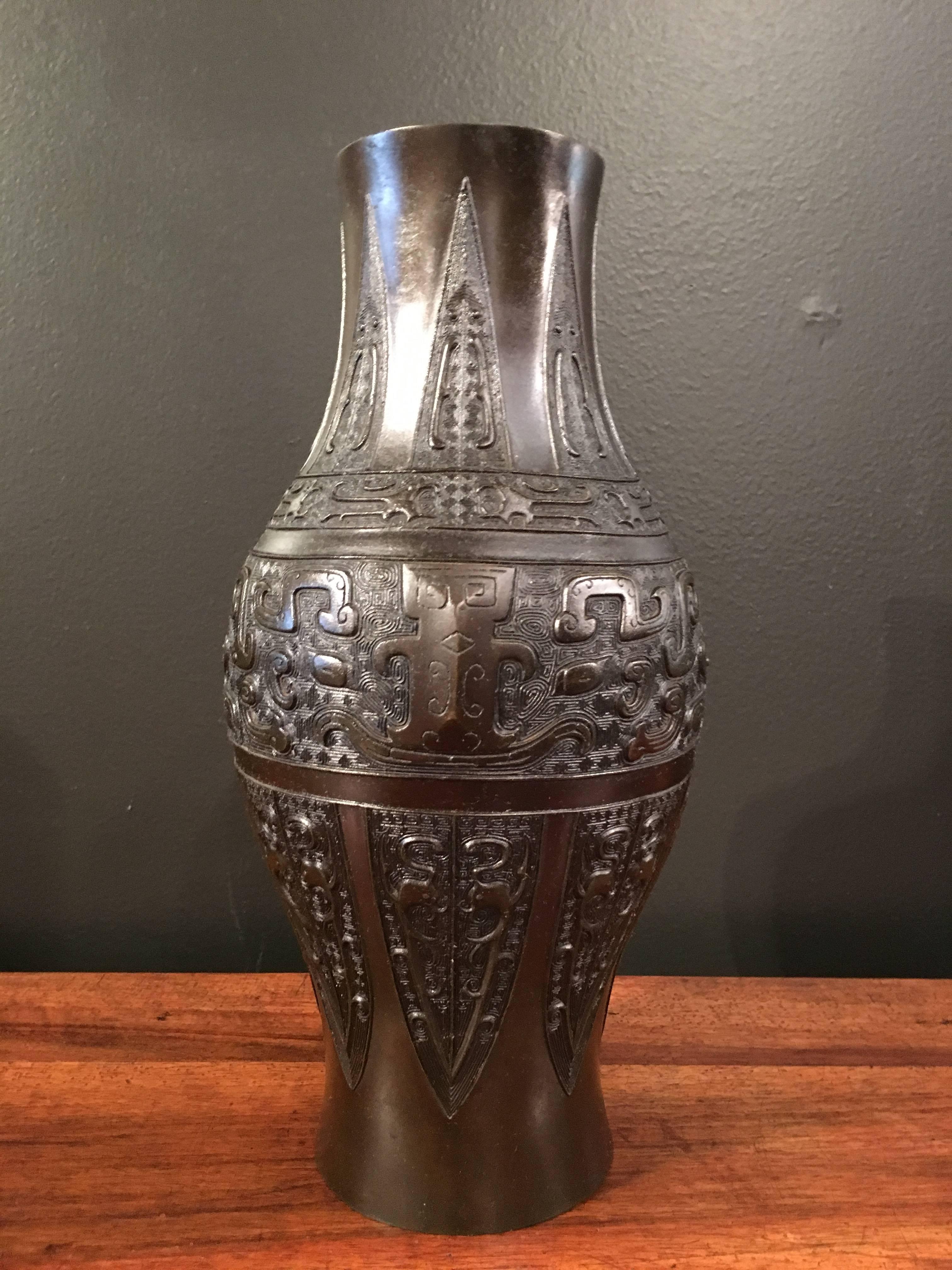 The vase of elegant ovoid baluster form and featuring well cast archaistic designs. 

The main design cast as a pair of large taotie masks set upon a leiwen diaper ground, with a pair of opposing kui dragons on either side of the mask. The upper