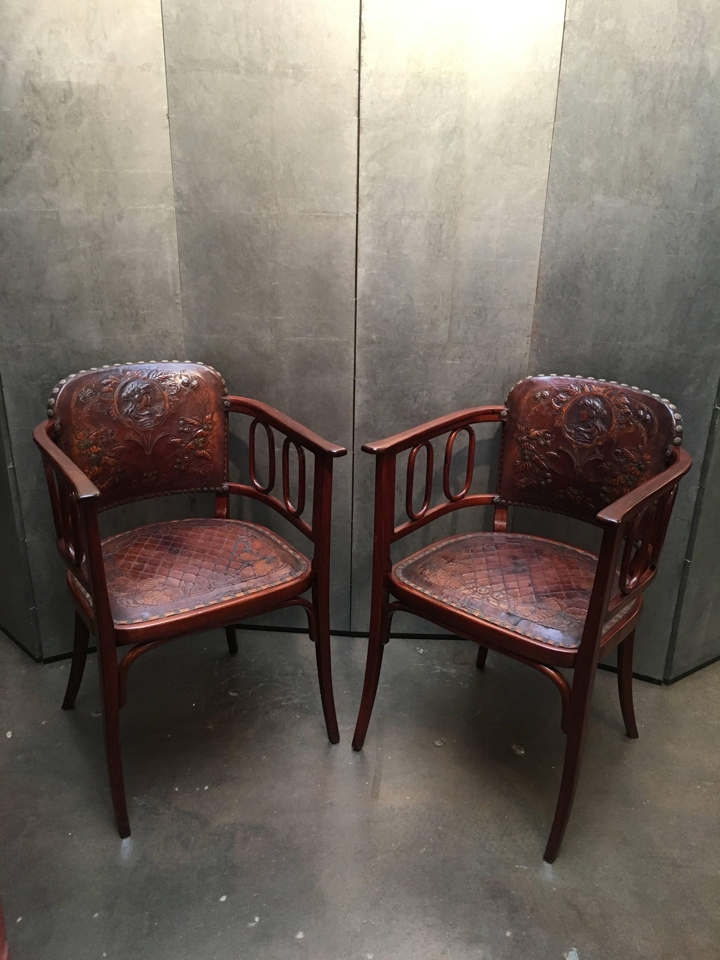 A pair of gorgeous stained bent beechwood armchairs upholstered in custom hand tooled period Art Nouveau leather. 
Both chairs with beautiful curvilinear lines throughout, from the slightly arched back to the curved arms, and saber legs. A neat row