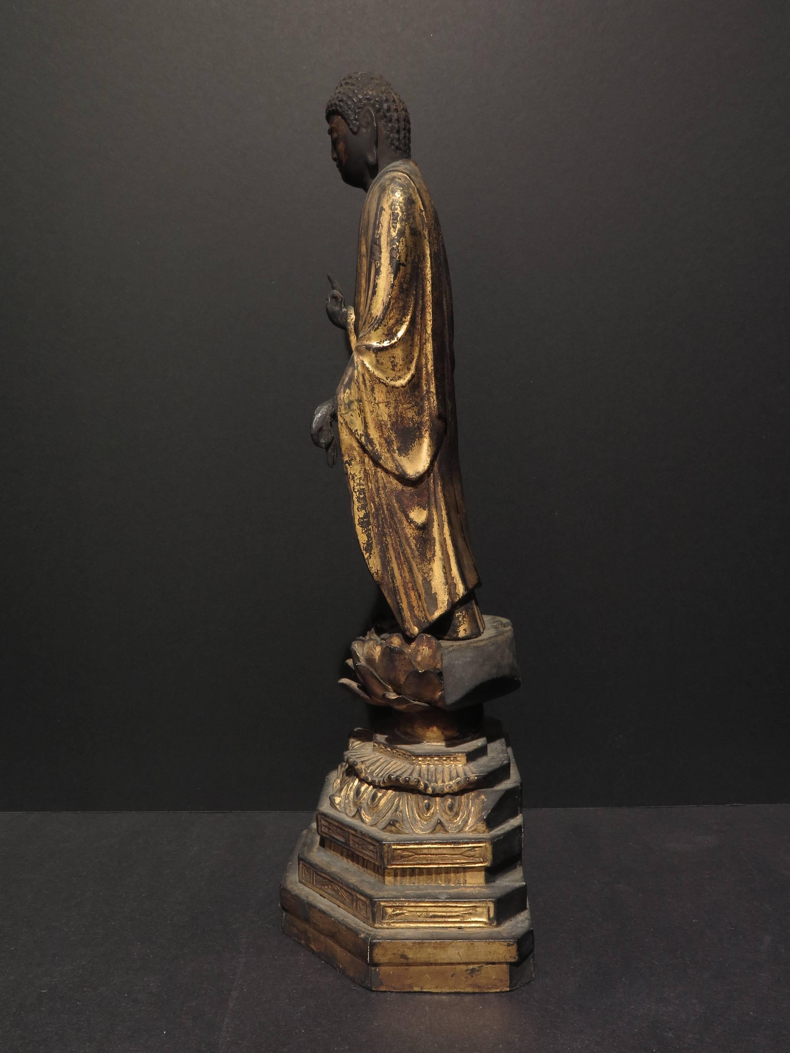 Beautiful gilt wooden standing Amida Buddha on a lotus pedestal. Serene expression with downcast eyes. Jewels set into ushnisha and forehead. Beautifully draped gilt robe.
Joined block hollow core sculptural technique is used to prevent cracks from