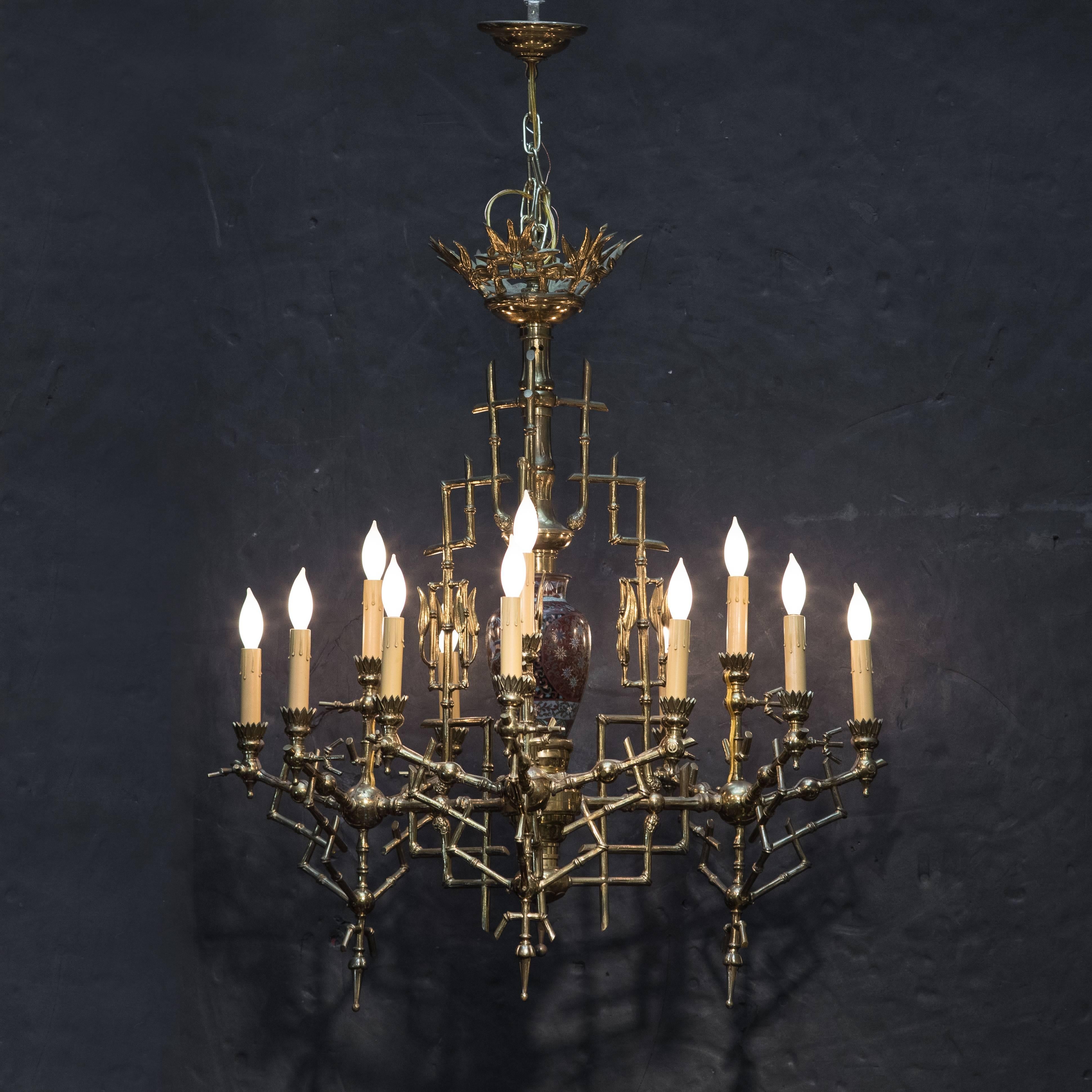 A stunning antique faux bamboo brass, three-arm, twelve-light chandelier.
The brass structure of the chandelier formed as geometric bamboo segments. The body of the chandelier featuring a mounted antique Japanese cloisonné vase.
With three arms,