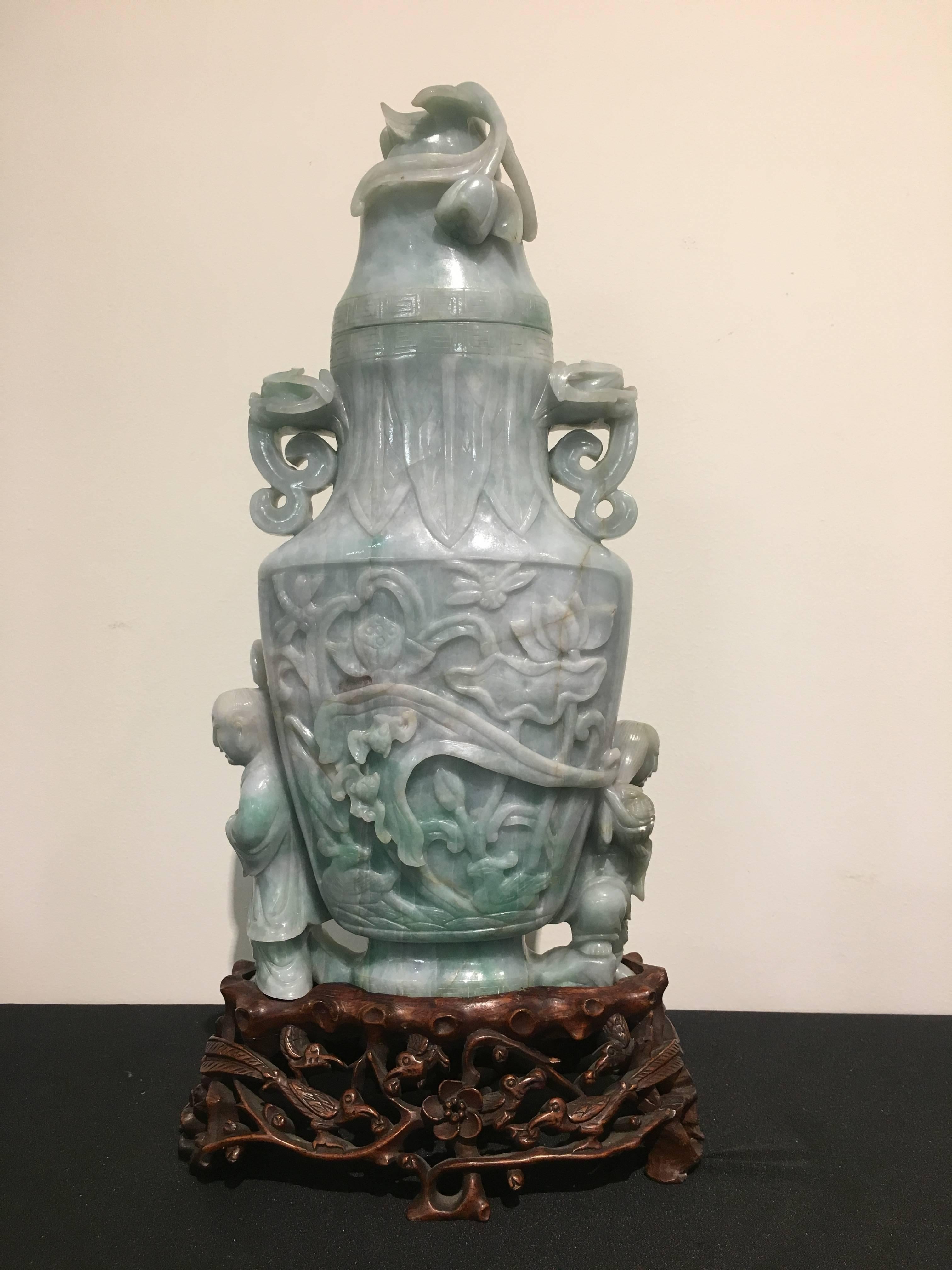 A large and impressive Chinese caved jade vase, Republic Period, circa 1930. 

Carved from one massive piece of jade. The vase carved with the He He Er Xian, the Immortal Twin Boys of the Taoist pantheon, supporting the sides. The body carved with