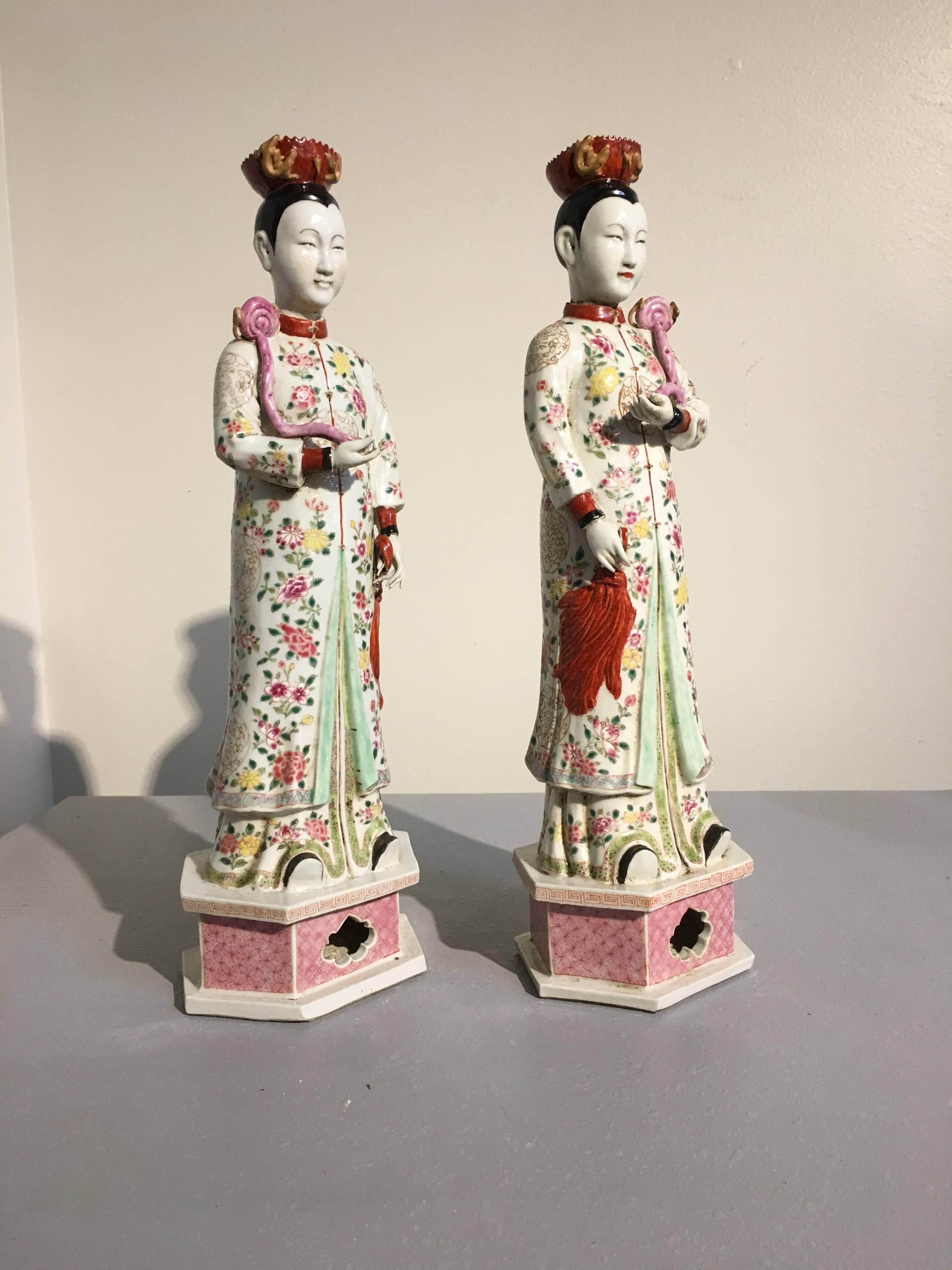 A beautiful pair of famille rose enameled Chinese nodding porcelain models of court ladies. Made of the export market during Daoguang period (1820 to 1850).
The gracious maidens stand upon a hexagonal plinth, wearing long informal surcoats