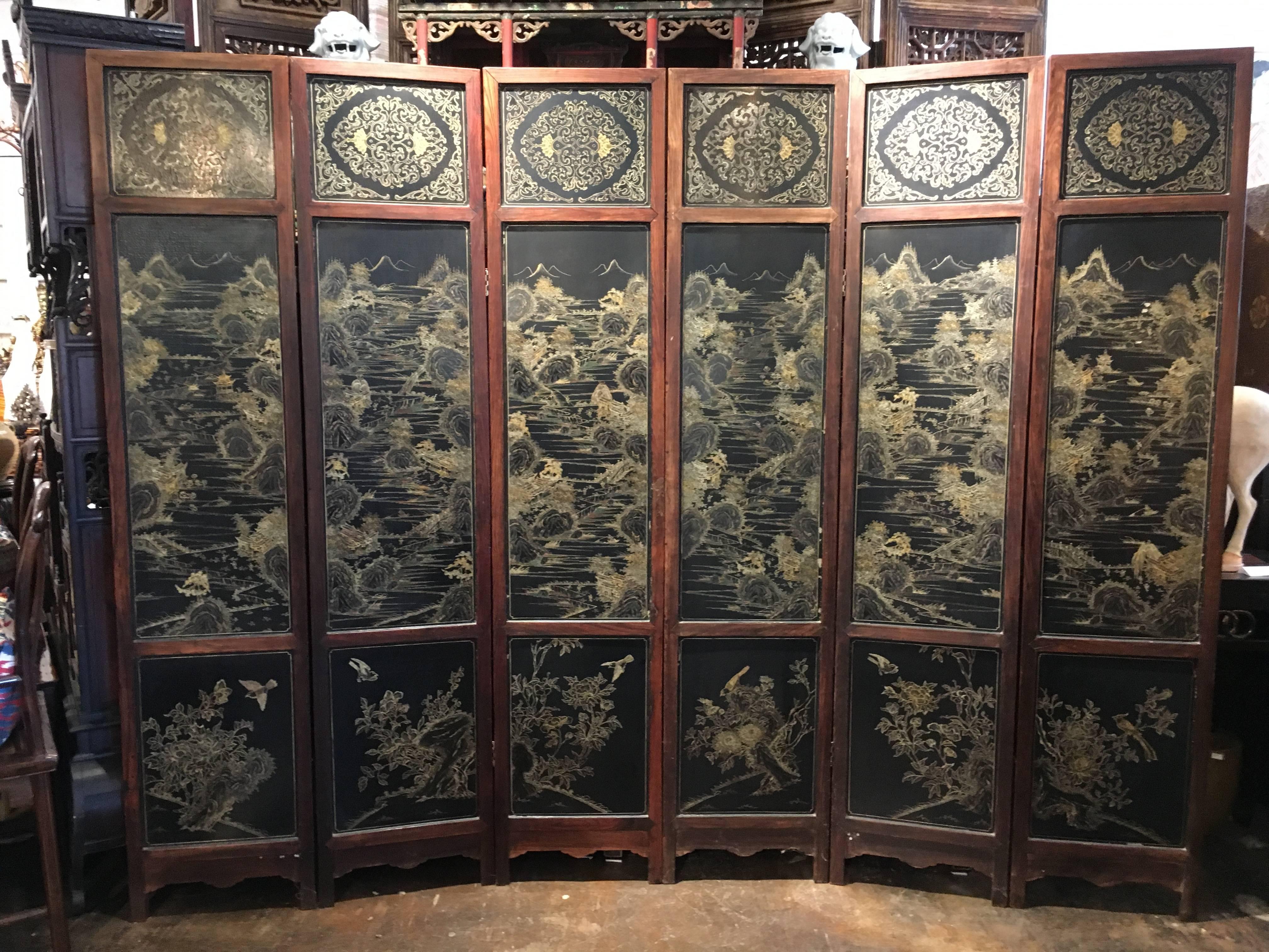 A very fine mid-Qing Dynasty Chinese hardwood and lacquer six-panel screen, Jailing Period, circa 1800. 
The hardwood frame inset with black lacquer panels. One side features an overlay of jade, hardstone, coral, and wood in the Hundred Antiques