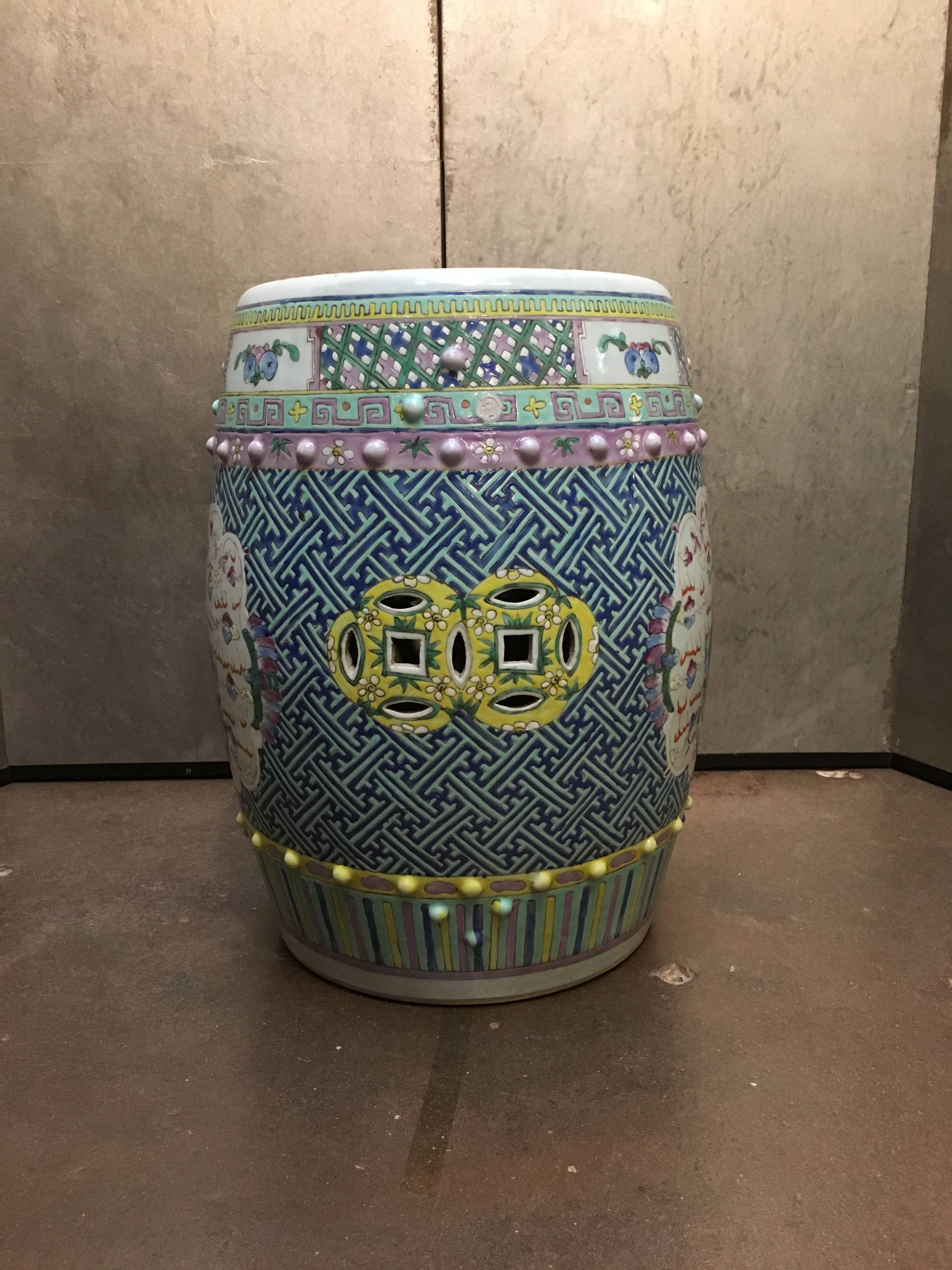 A beautiful Chinese famille rose enameled porcelain garden stool, Qing dynasty, mid-19th century. Of traditional drum shape, and painted with stunning raised enamels in blue, yellow, green, pink and purple.

The body decorated with raised enamels