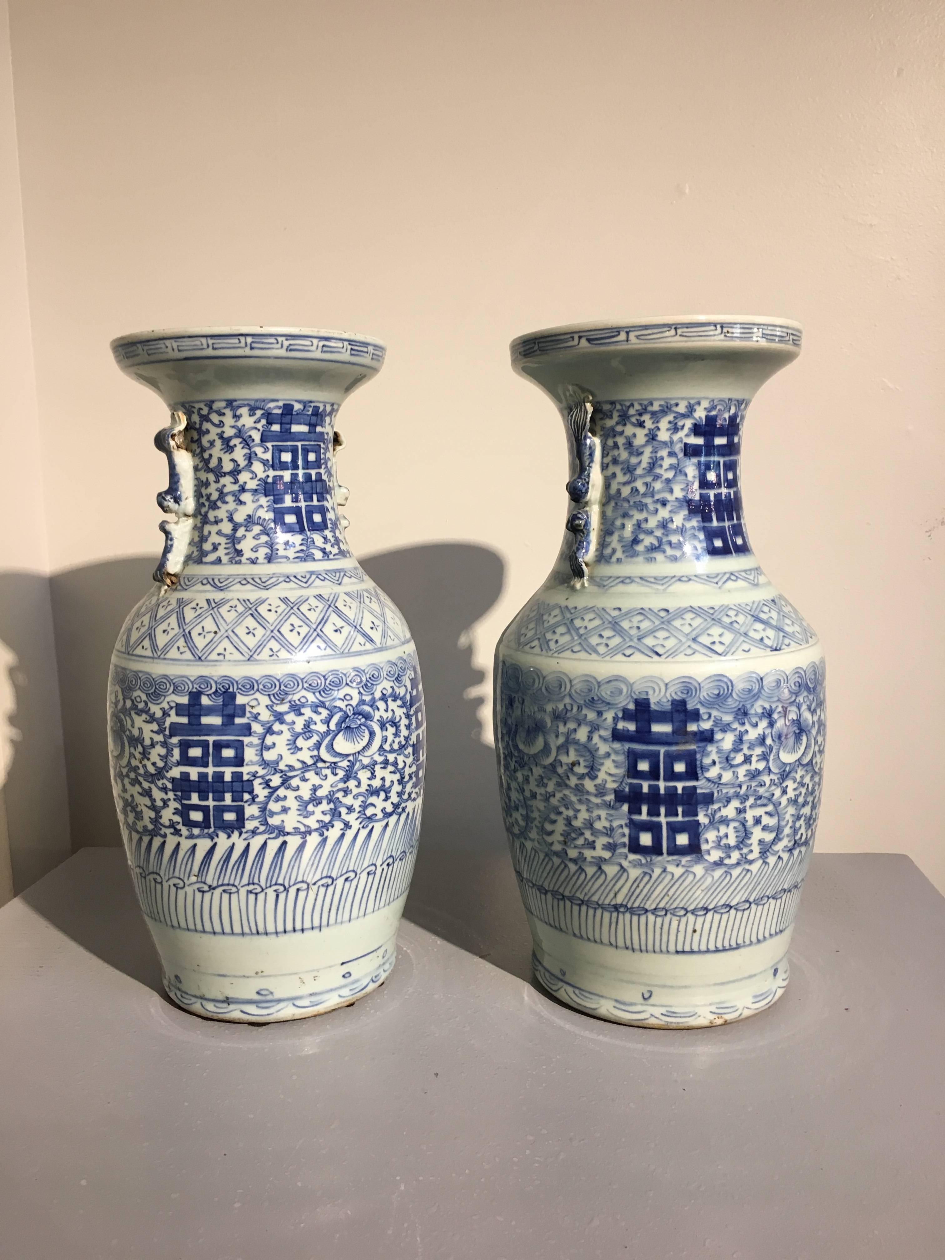 A near pair of Chinese porcelain blue and white double happiness baluster vases. The vases painted in a rich cobalt on a white ground, featuring a Traditional Design of the character Shuangxi or 