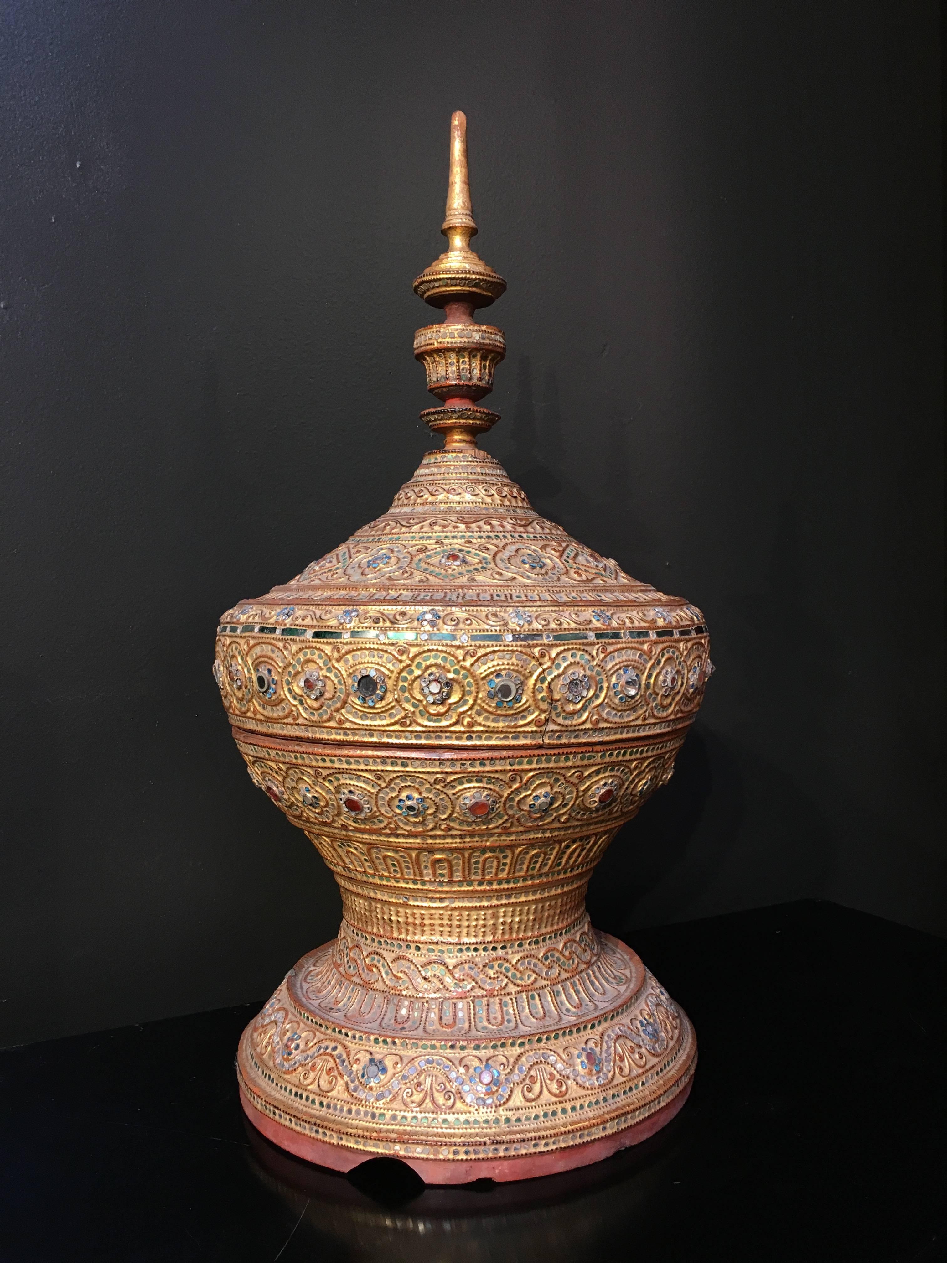 Ein prächtiges birmanisches Opfergefäß aus der Mandalay-Periode, genannt hsun-ok, frühes 20. Jahrhundert. 
Die Form erinnert an einen Stupa, ein buddhistisches Baudenkmal zu Ehren einer heiligen Stätte.
Dieses aus Bambus gefertigte, mit Lack