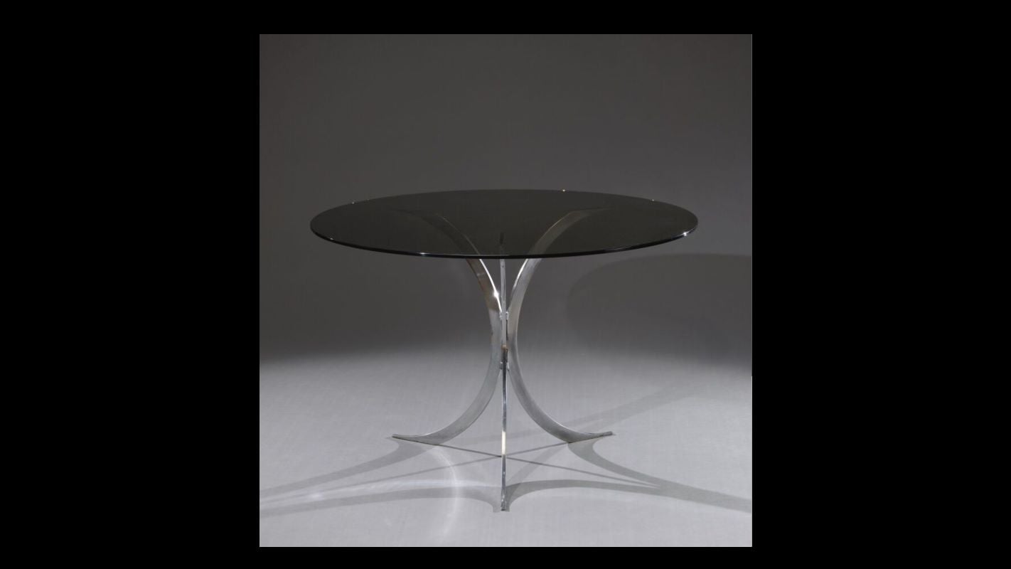 Esta magnífica mesa Christofle, diseñada por Boris Tabacoff, es un auténtico testimonio del diseño francés de los años 1970. Sus pies cromados aportan un toque de modernidad y brillo, mientras que la placa de hierro fumé ofrece una elegancia