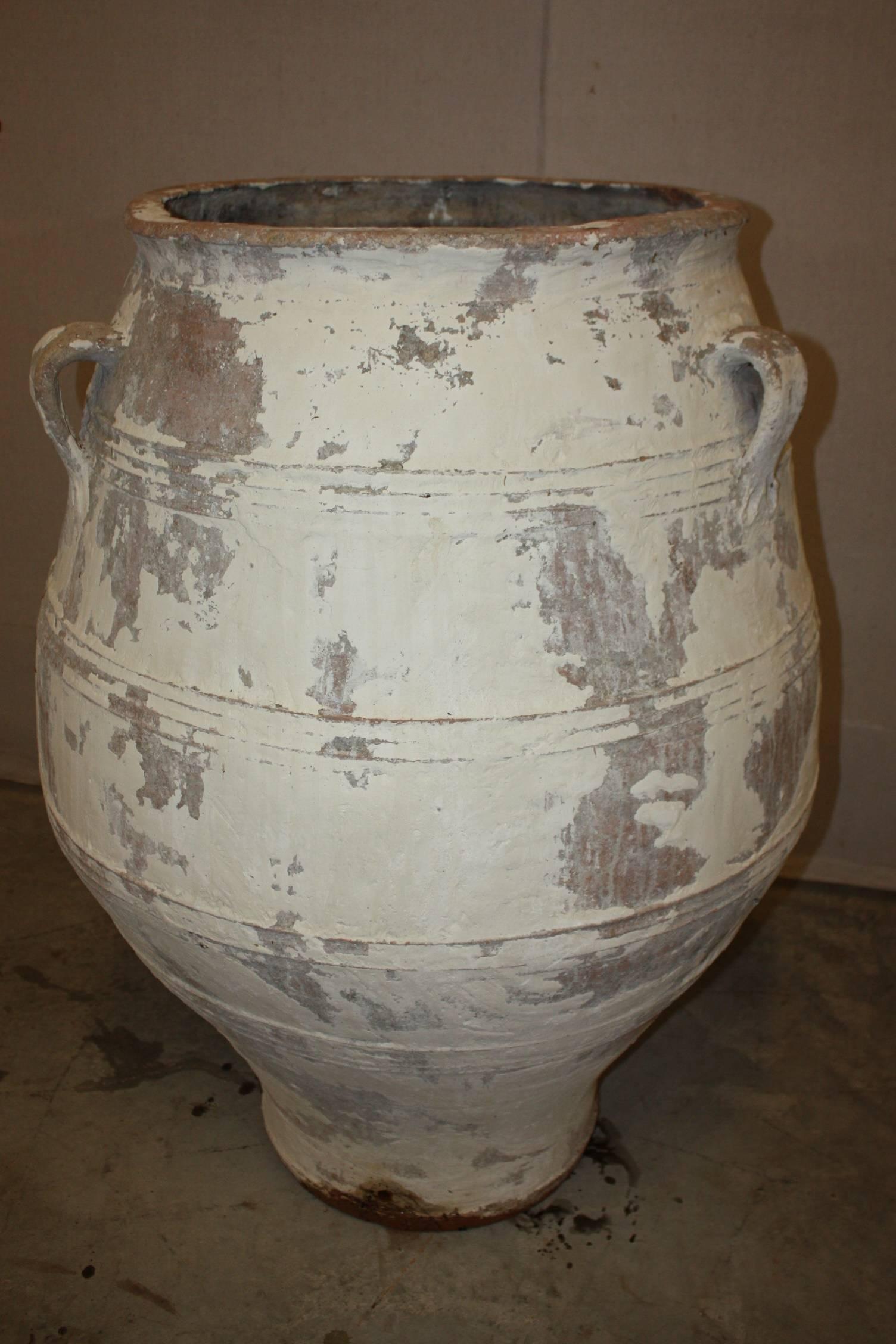 Very large Greek terracotta olive jars with antiqued white paint. We have several in stock in all sizes, shapes and colors. Large olive jars provide a wonderful architectural feature to outdoor gardens and landscape. Also could be used as a planter