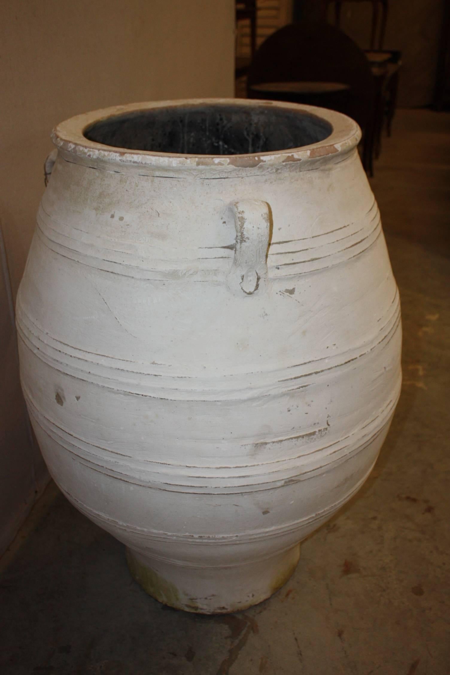 Very large Greek terracotta olive jars with antiqued white paint. We have several in stock in all sizes, shapes and colors. Large olive jars provide a wonderful architectural feature to outdoor gardens and landscape. Also could be used as a planter