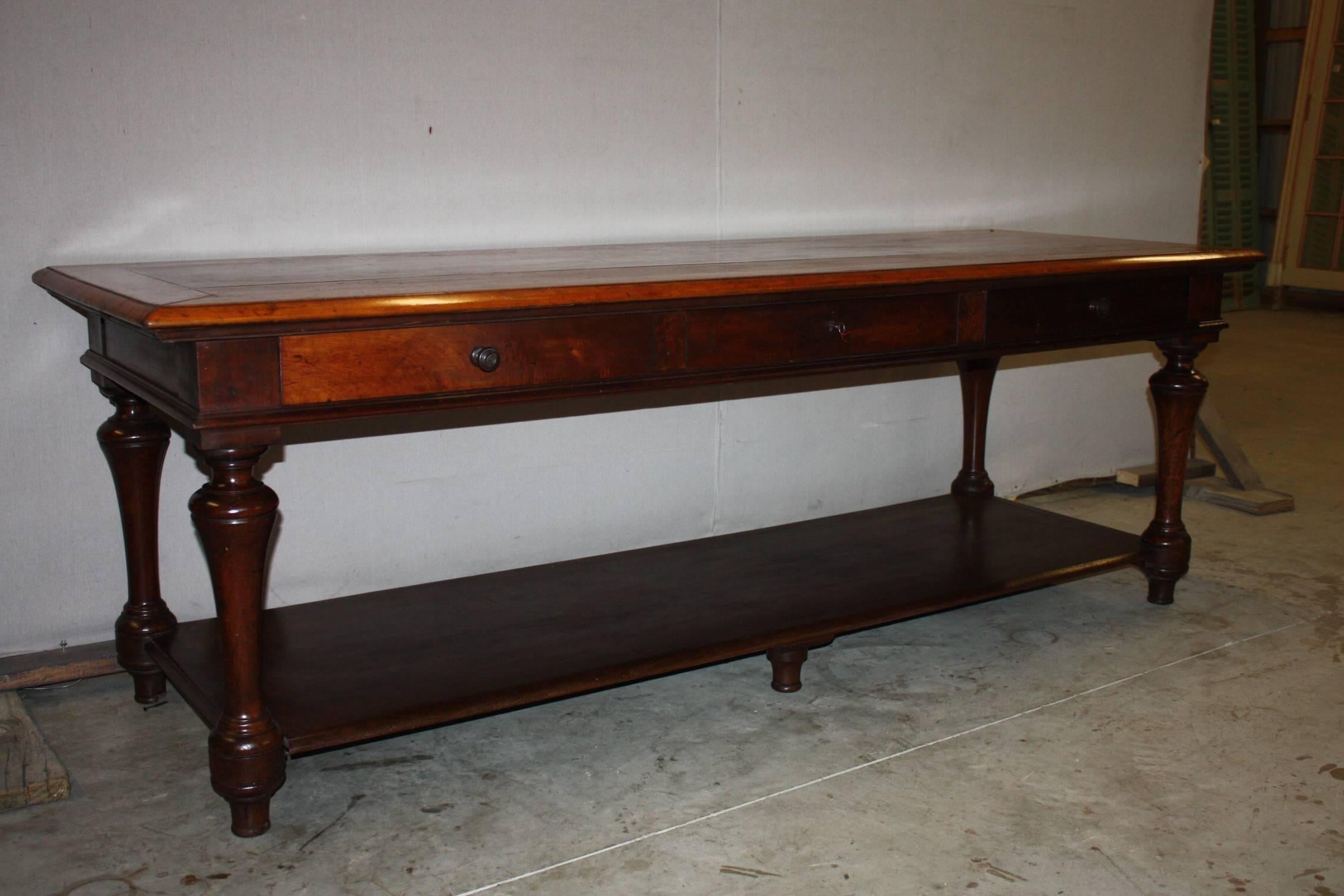 This rare French stained pine table was originally used in a drapers' Haberdashery shop for measuring lengths of fabric. It's beautiful from all sides and would be the perfect kitchen island. All legs are detailed turned pine and feature a bottom