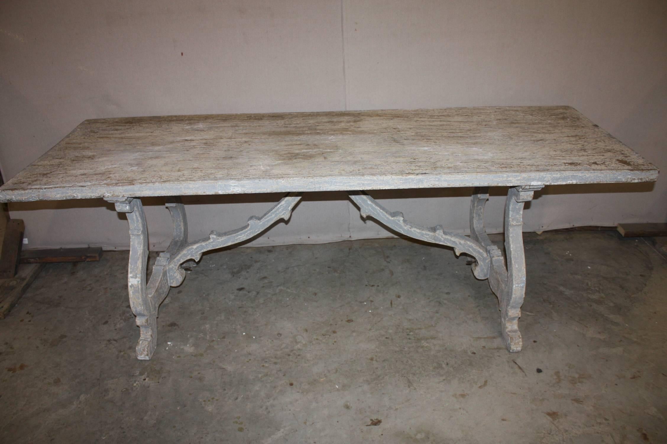 Painted Swedish trestle table with rectangular top raised on shaped trestle supports with under-scrolled feet joined by a stretcher. Light blue paint with excellent patina.