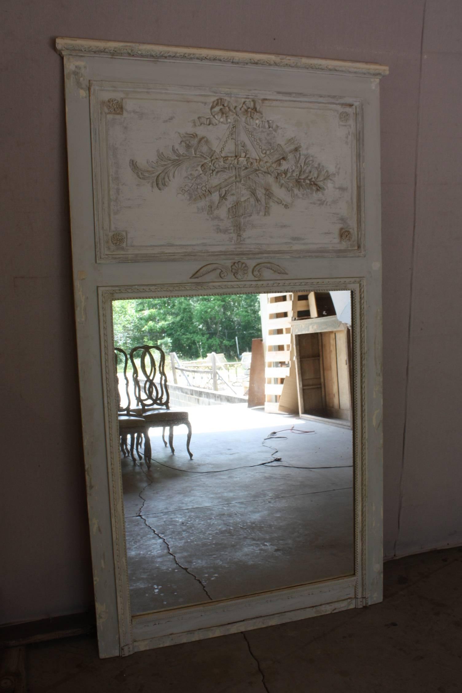 This Louis XVI style Trumeau with original paints exposed in layers of natural ware is truly a statement peace. Very simply and sleek with a beautiful clean white patina makes this mirror perfect for all design applications.