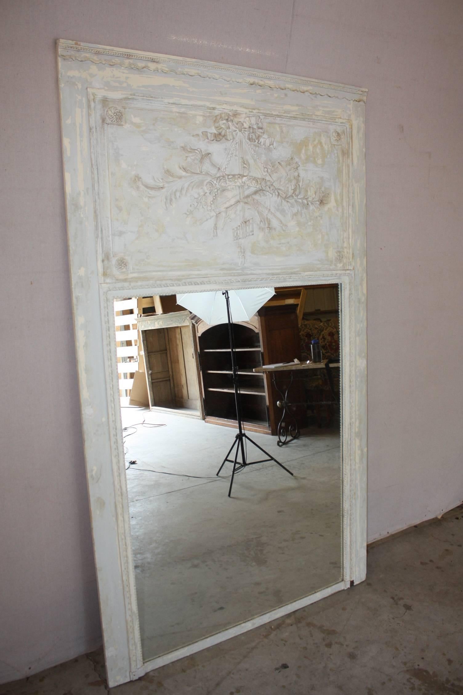 This Louis XVI style trumeau with original paints exposed in layers of natural ware is truly a statement peace. Very simply and sleek with a beautiful clean white patina makes this mirror perfect for all design applications.