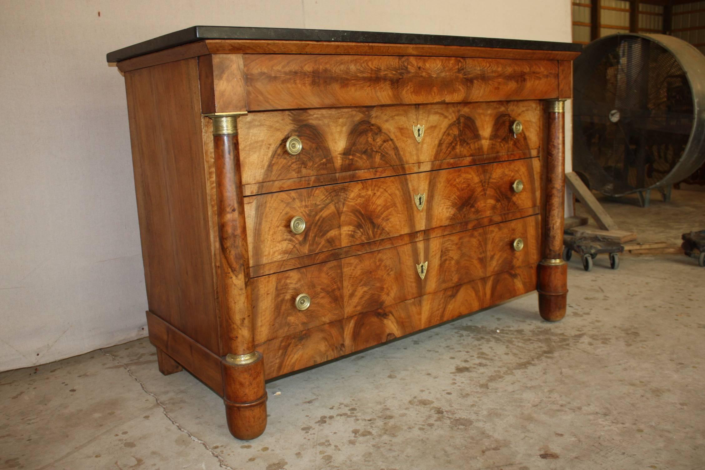 This Classic French Empire period commode features a gorgeous burl walnut facade and bronze ornaments on the columns framing the chest and a beautiful marble top. An absolutely stunning chest that will make a bold statement in your entry way,