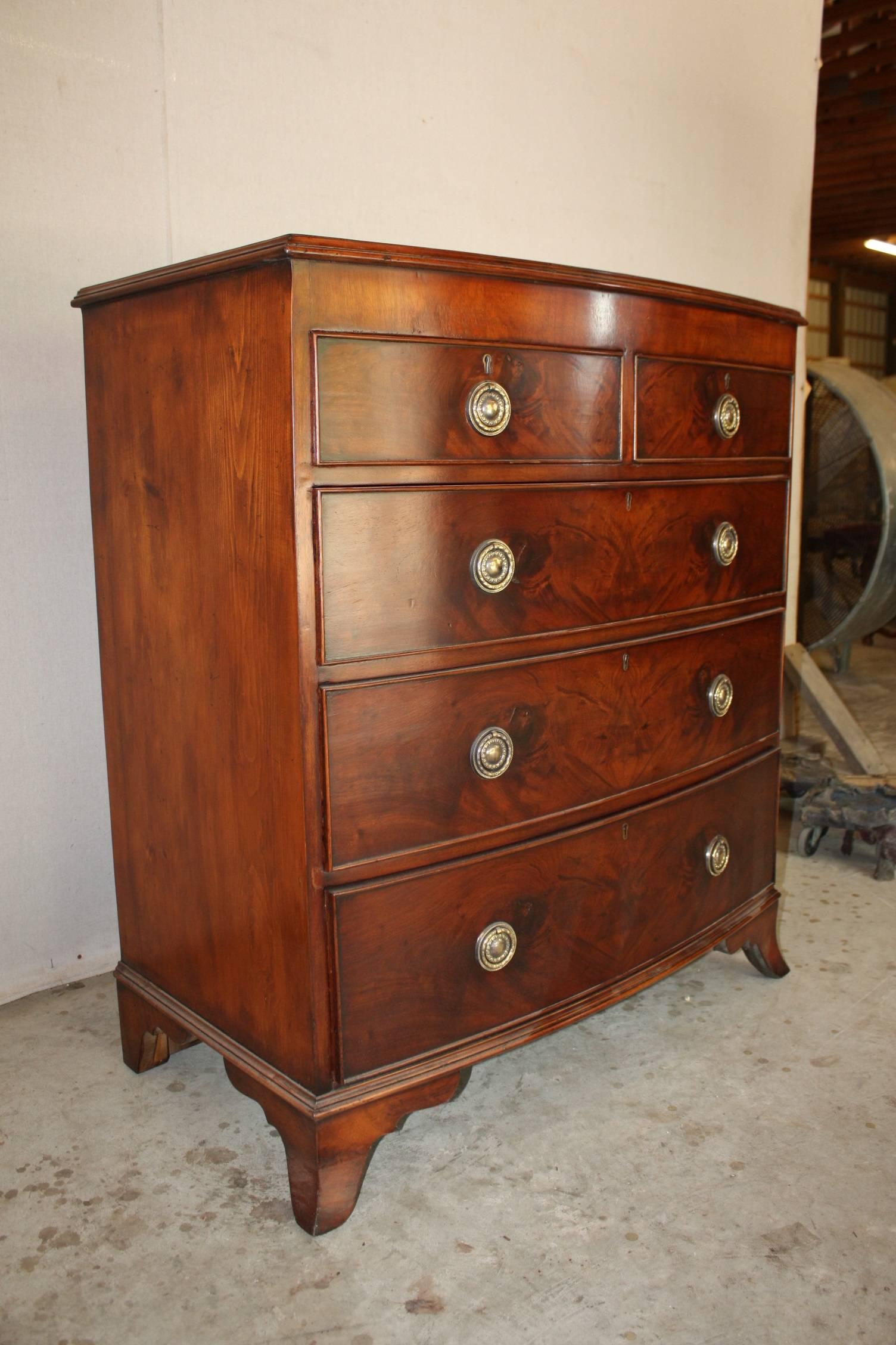 A very large 19th century antique mahogany bow fronted chest of drawers, with two smaller drawers over three large graduated drawers sitting on four turned legs.