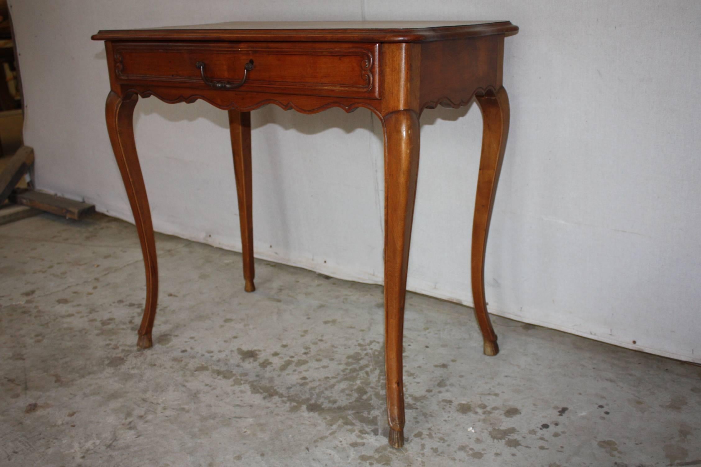 Walnut French side table with cabriole legs, hoof foot and a single drawer.