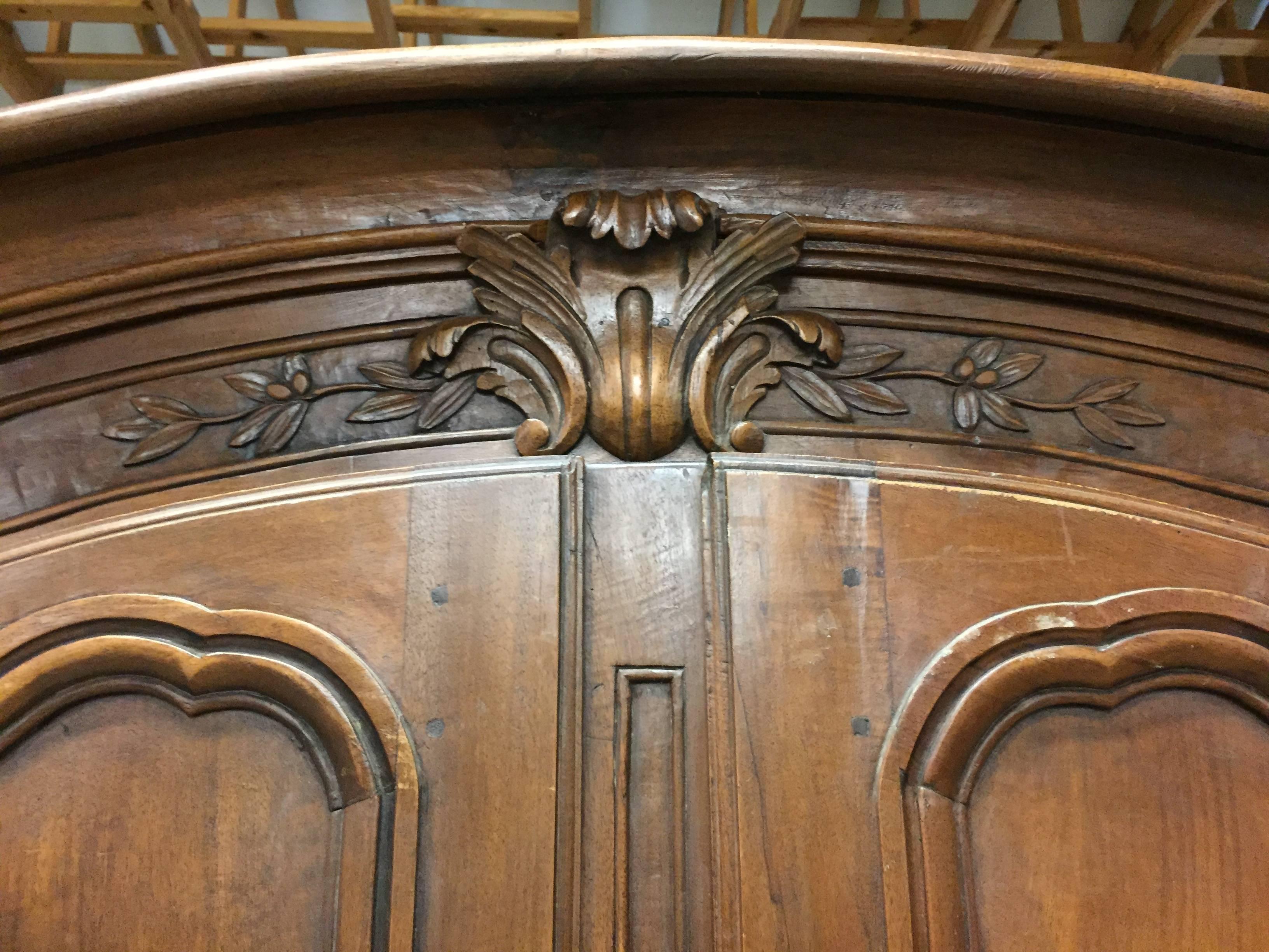 A beautiful armoire in French walnut from the period of Louis XV, who ruled France from 1715-1774. A perfect example from the Lyon region of France. With scalloped apron and carved escargot feet, and original steel lock and hinges.