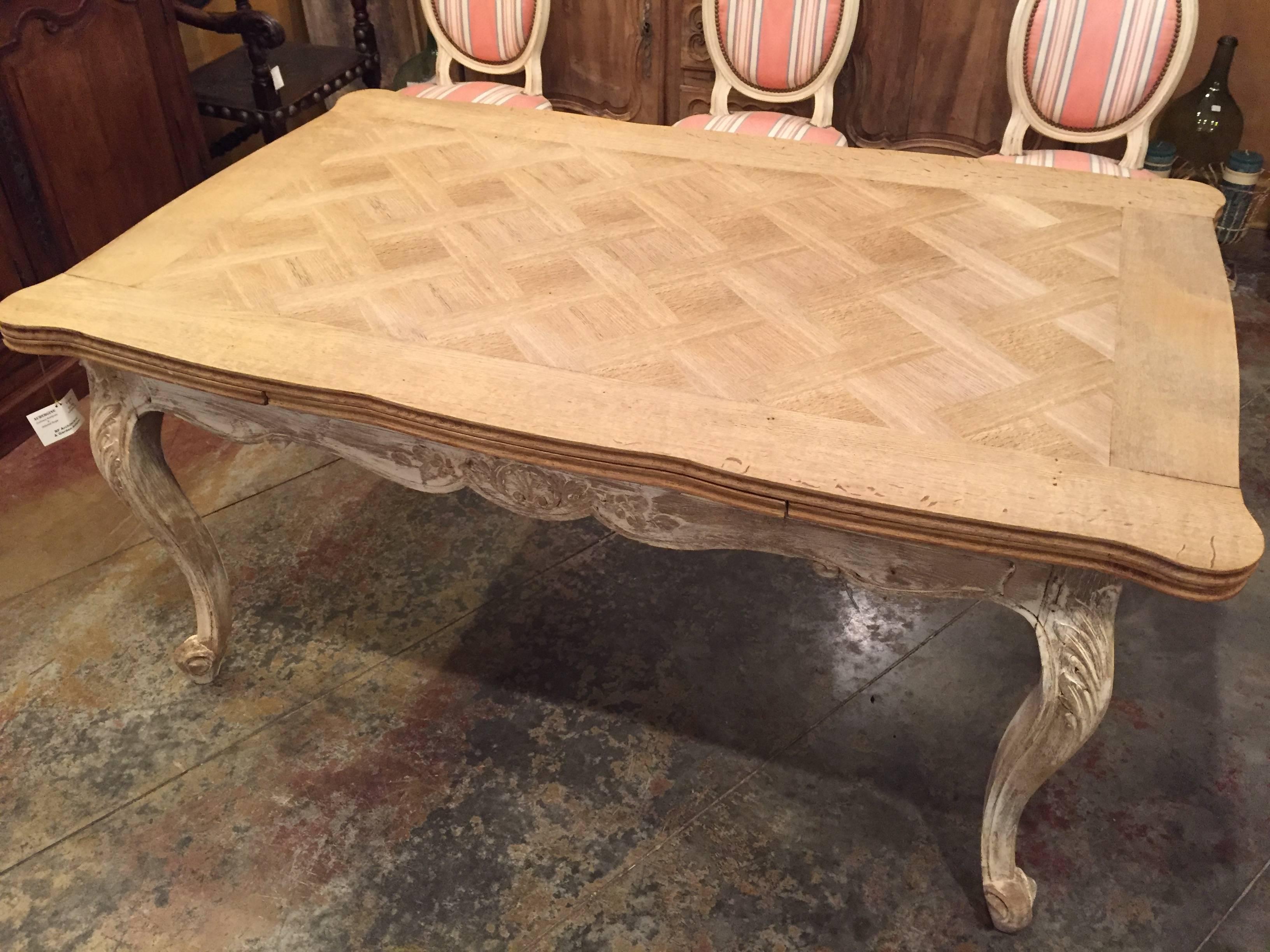 French draw-leaf dining table with a carefully stripped parquet top and painted base. The leaves can be easily drawn out without damaging the finish.

The table fully extended is 98