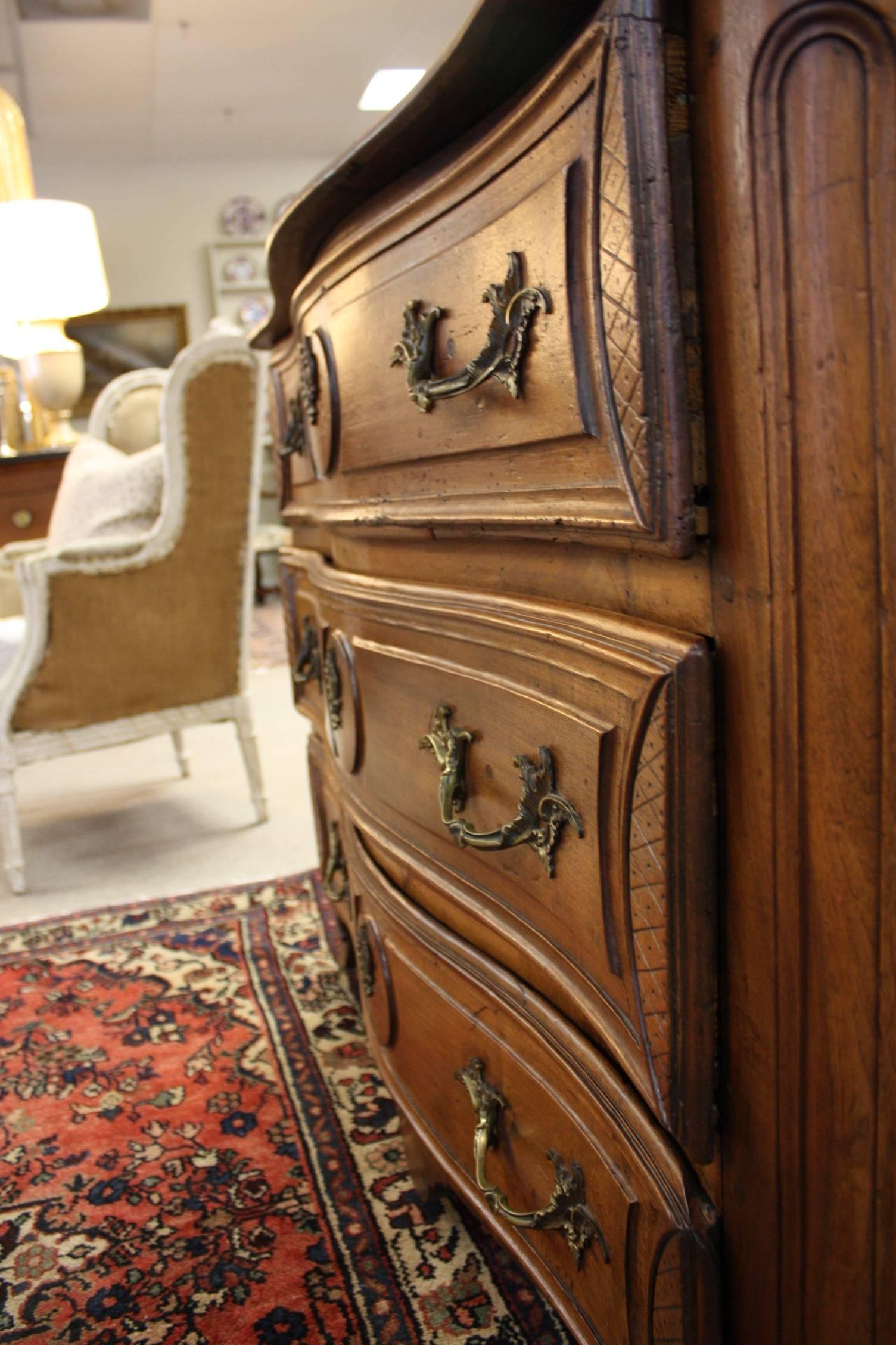 Beautifully carved and polished walnut French commode consisting of three drawers and decorative handles and lock plates.