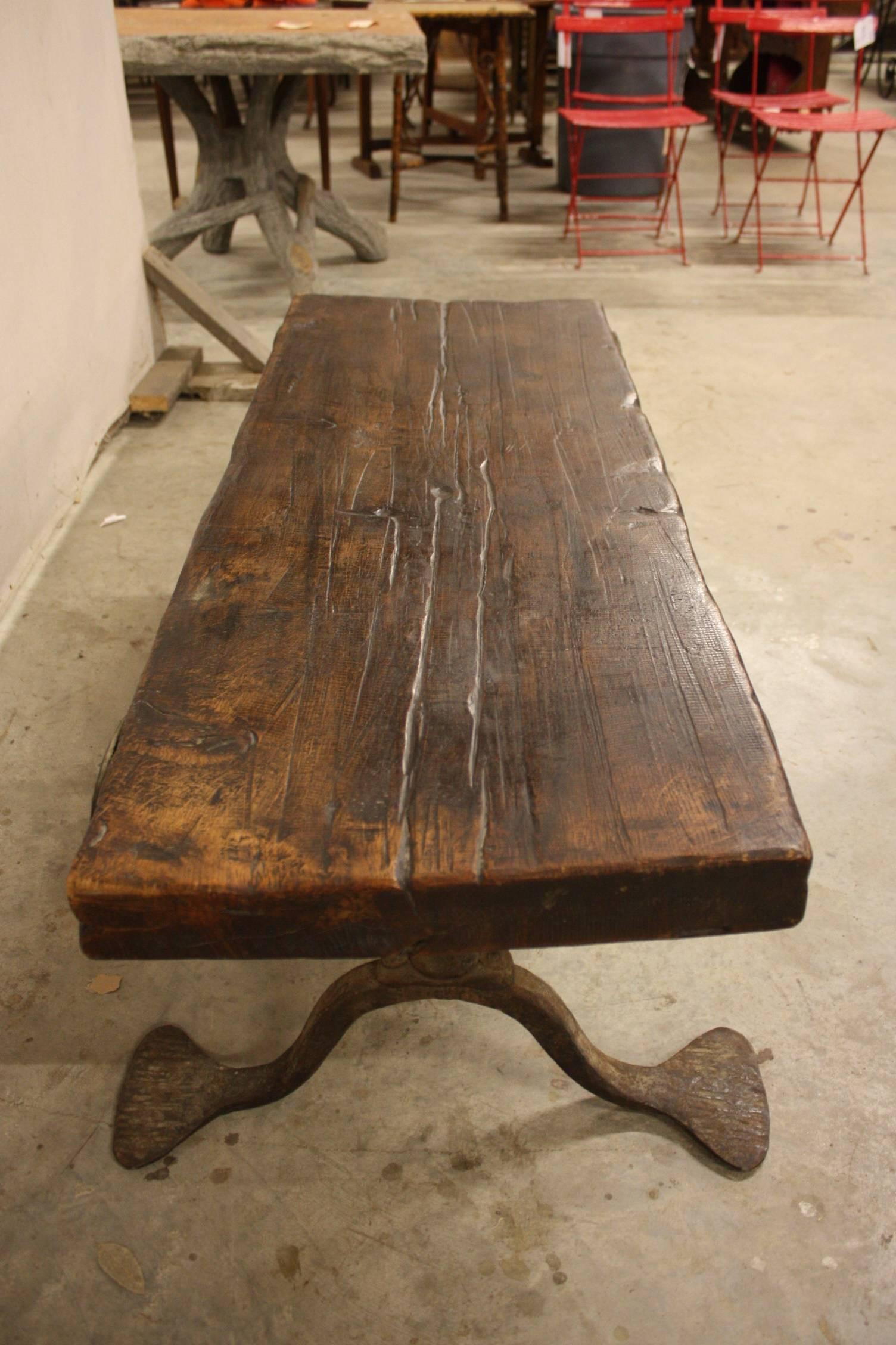 A wonderful mid-19th century coffee table from France. Handsomely constructed with a fabulous hand-forged iron base and walnut top. Serves wonderfully as a coffee table or bench.