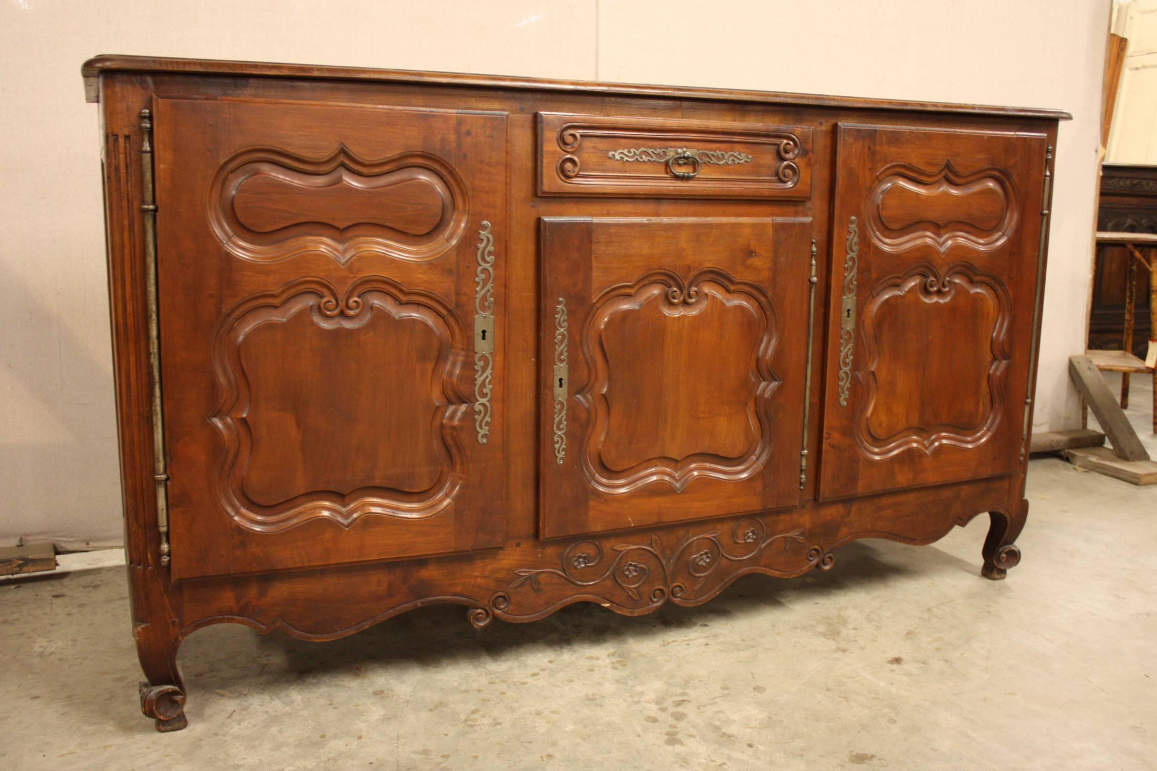 A Louis XV French walnut enfilade with a centre drawer, three cabinets with interior shelving, carved shaped apron and all resting on cabriole feet.