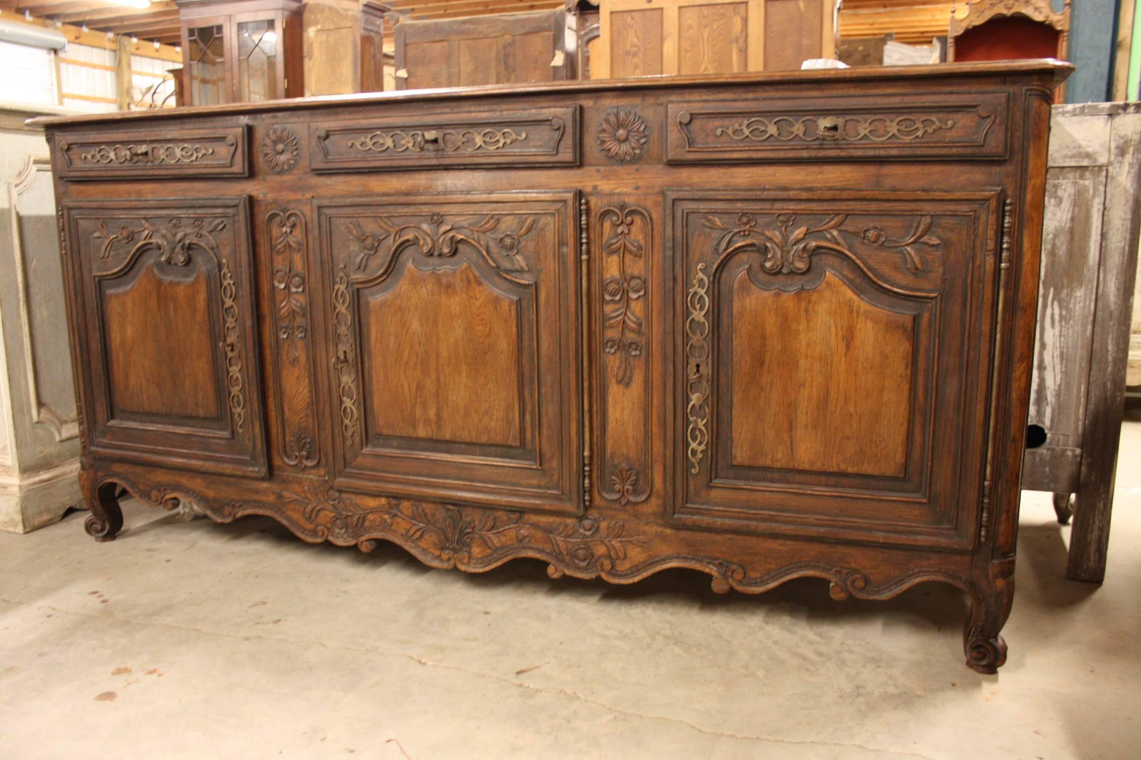 19th century buffet or sideboard in Louis XV country French style, then surrounding panels of highly figured burl and ribbon-grained fruit and nut woods to create a two-toned or two-textured effect. This example also boasts its original hand-forged