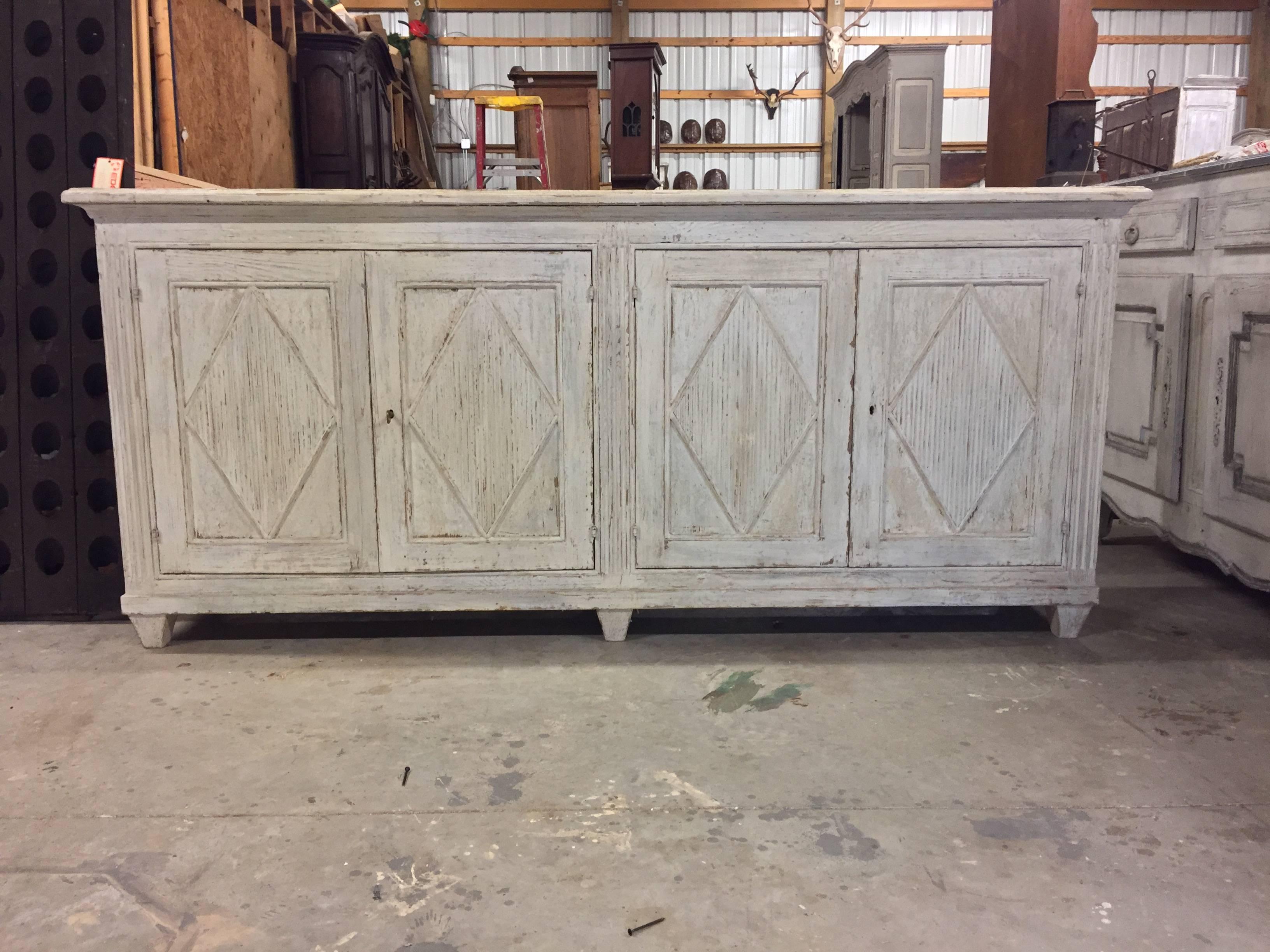 Large 19th century Swedish period Gustavian sideboard in Classic Gustavian style with four panelled doors with reeded diamond shaped lozenges on tapered feet. Wonderful find!