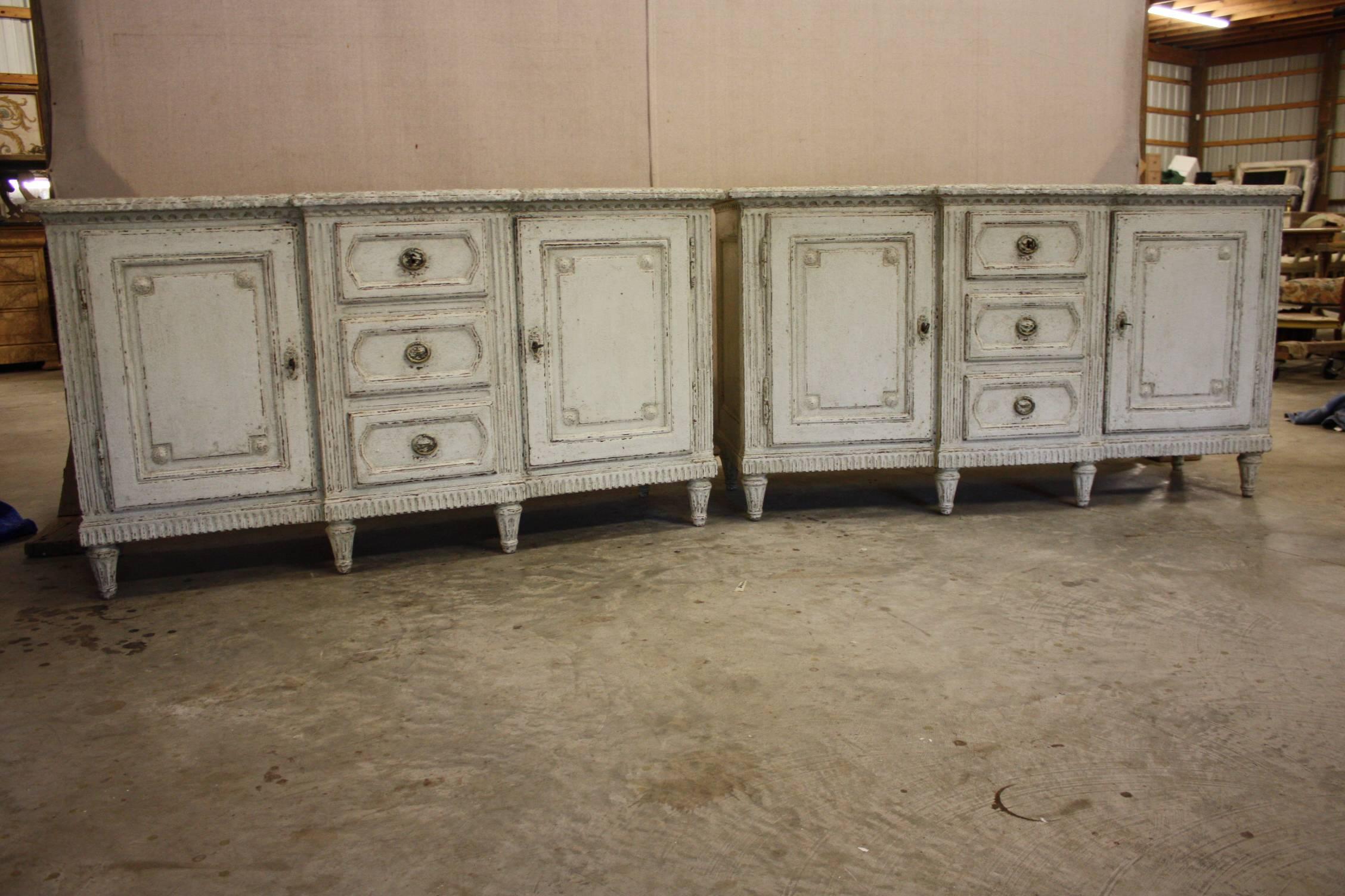 Elegant pair of antique French Louis XVI painted cabinets of drawers featuring Fine carved wood details and a faux marble top. These can be bought as a pair or sold separately.