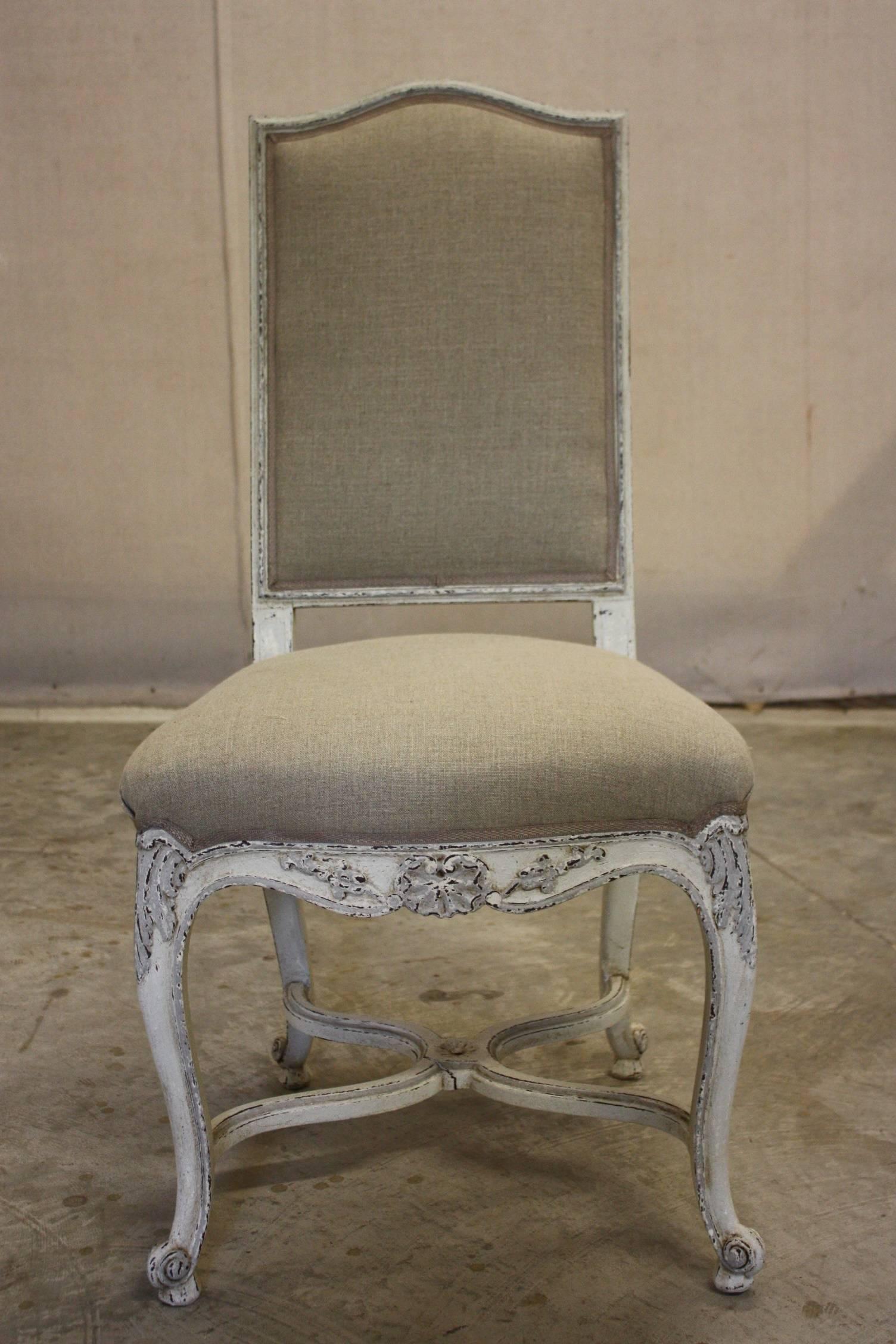 Set of eight painted late 19th century Louis XV style dining chairs upholstered in linen.