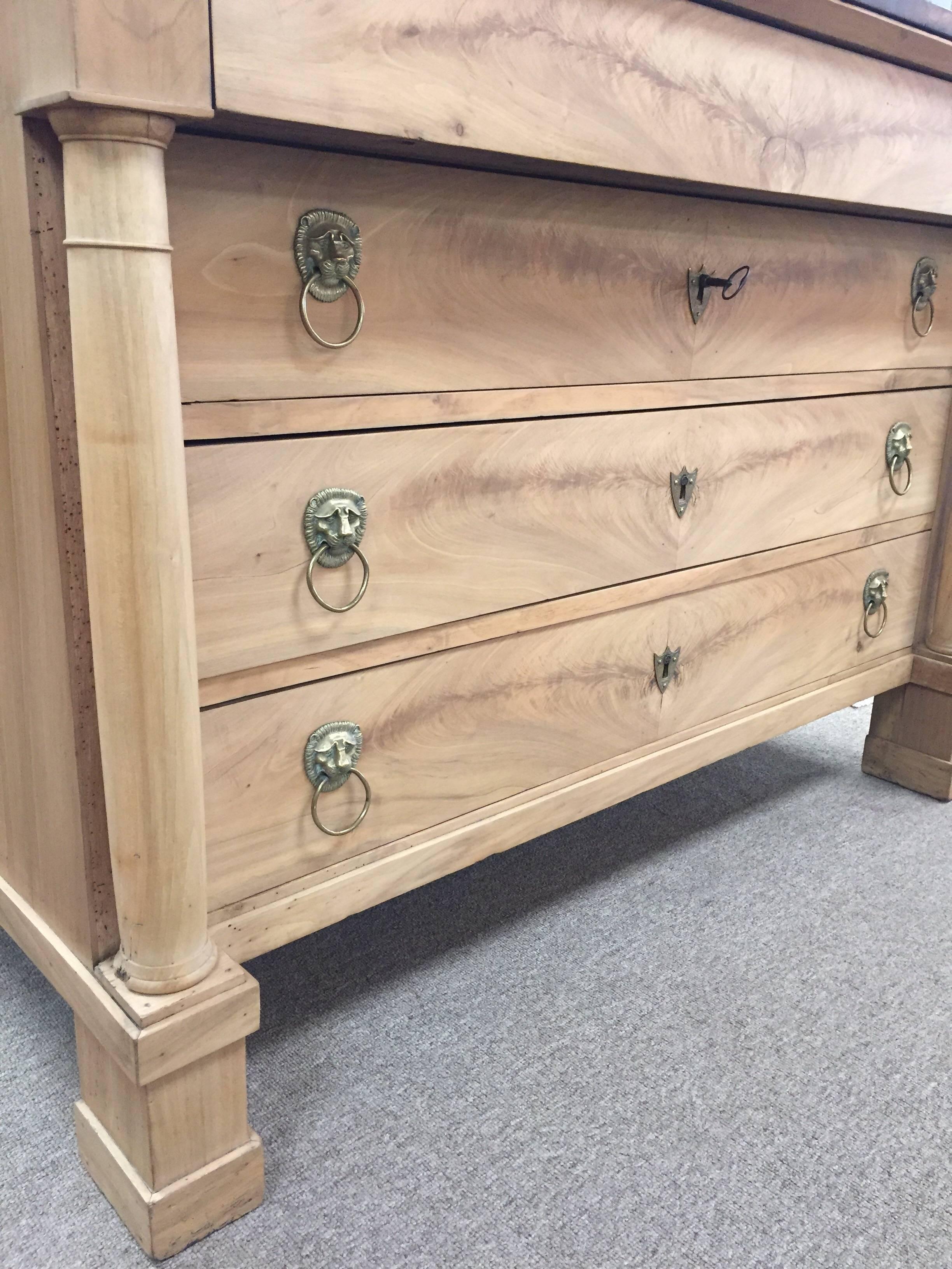 This 19th century French Empire commode is bleached walnut and has a beautiful black marble-top. There four long drawers with the top drawer having no hardware. Original hardware and key included.