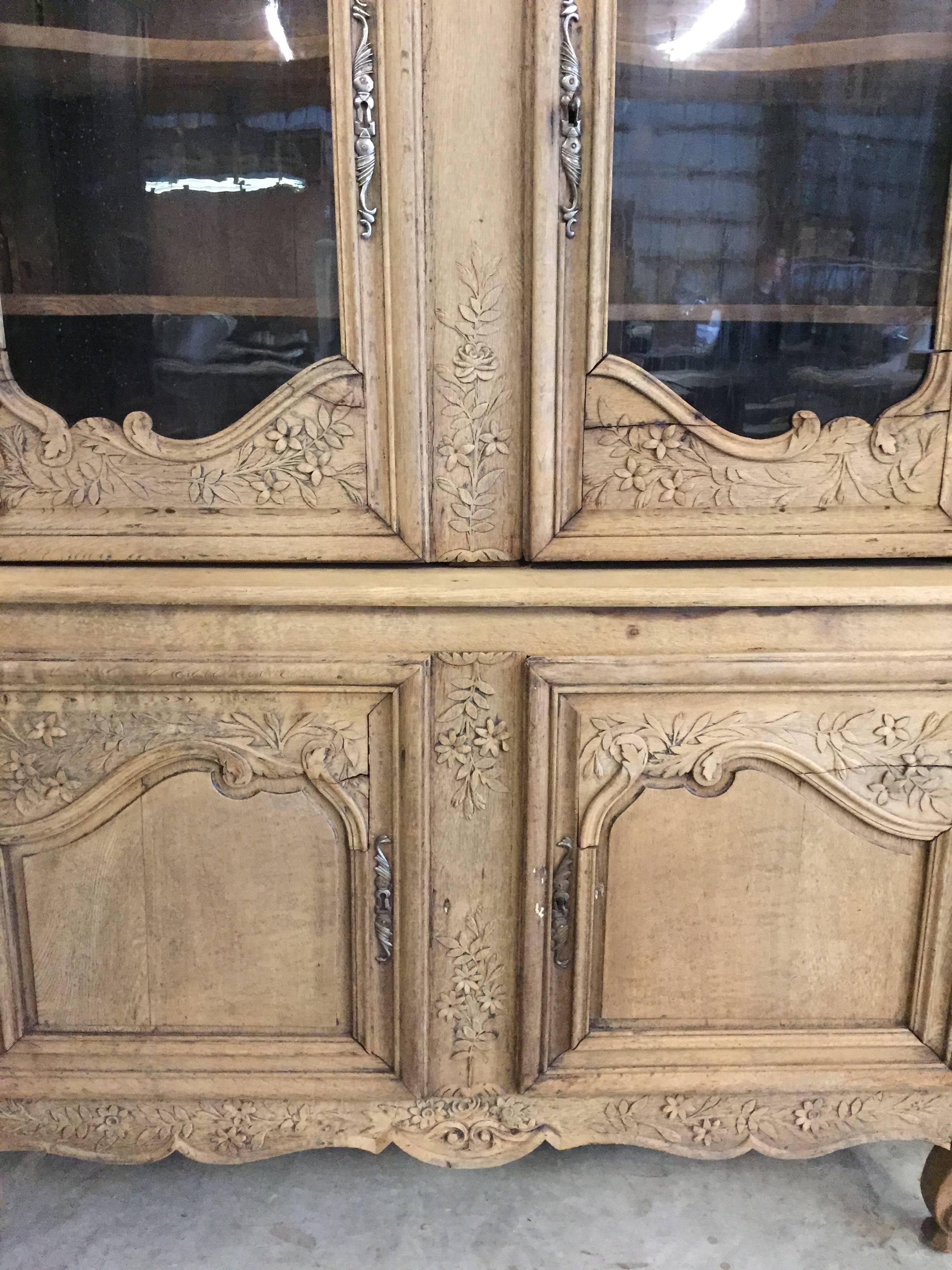 French 1+9th century bleached two part buffet deux corps with an upper cabinet of glass doors over a lower cabinet with two cutlery drawers and shelves inside.  Beautiful hand carved details and scalloped upper shelves.  