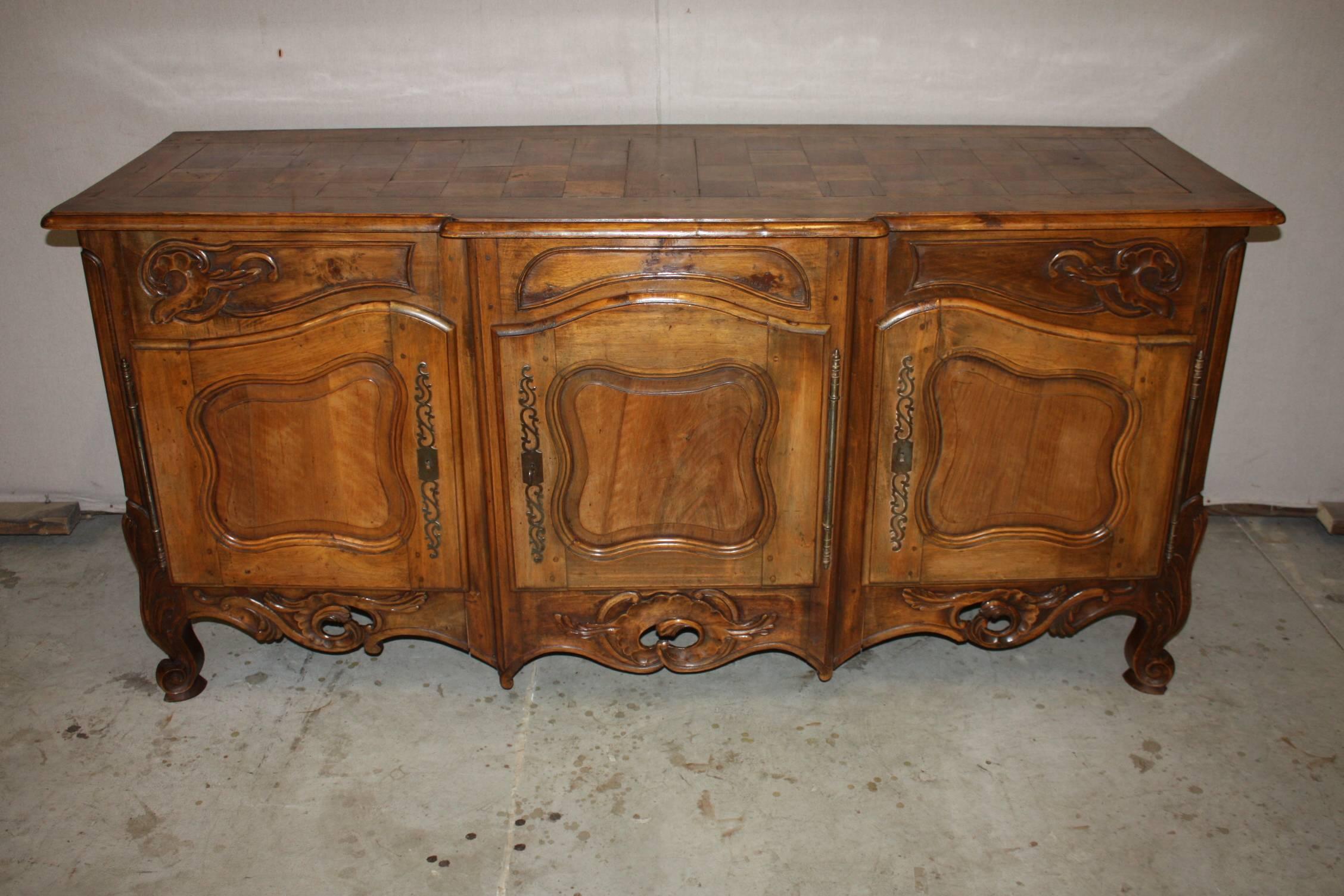 This is a very nice French walnut enfilade that dates to the late 1800's.  IT is rather unique in that it has drawers on each side. the top has a parka wood pattern.  The carvings are very nice on this buffet.