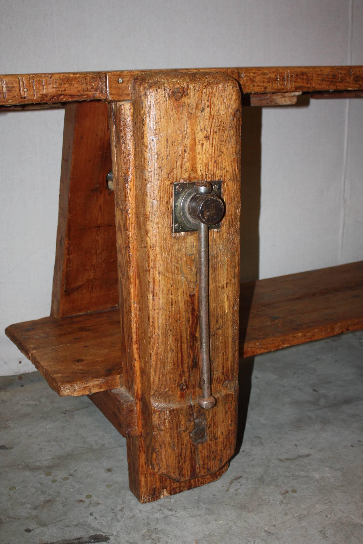 A magnificent large Italian work bench made of solid wood with wonderful patina. Constructed using traditional mortise and tenon connections that are secured by solid wood pegs. Has a bottom stretcher that also functions as a shelf. This work bench