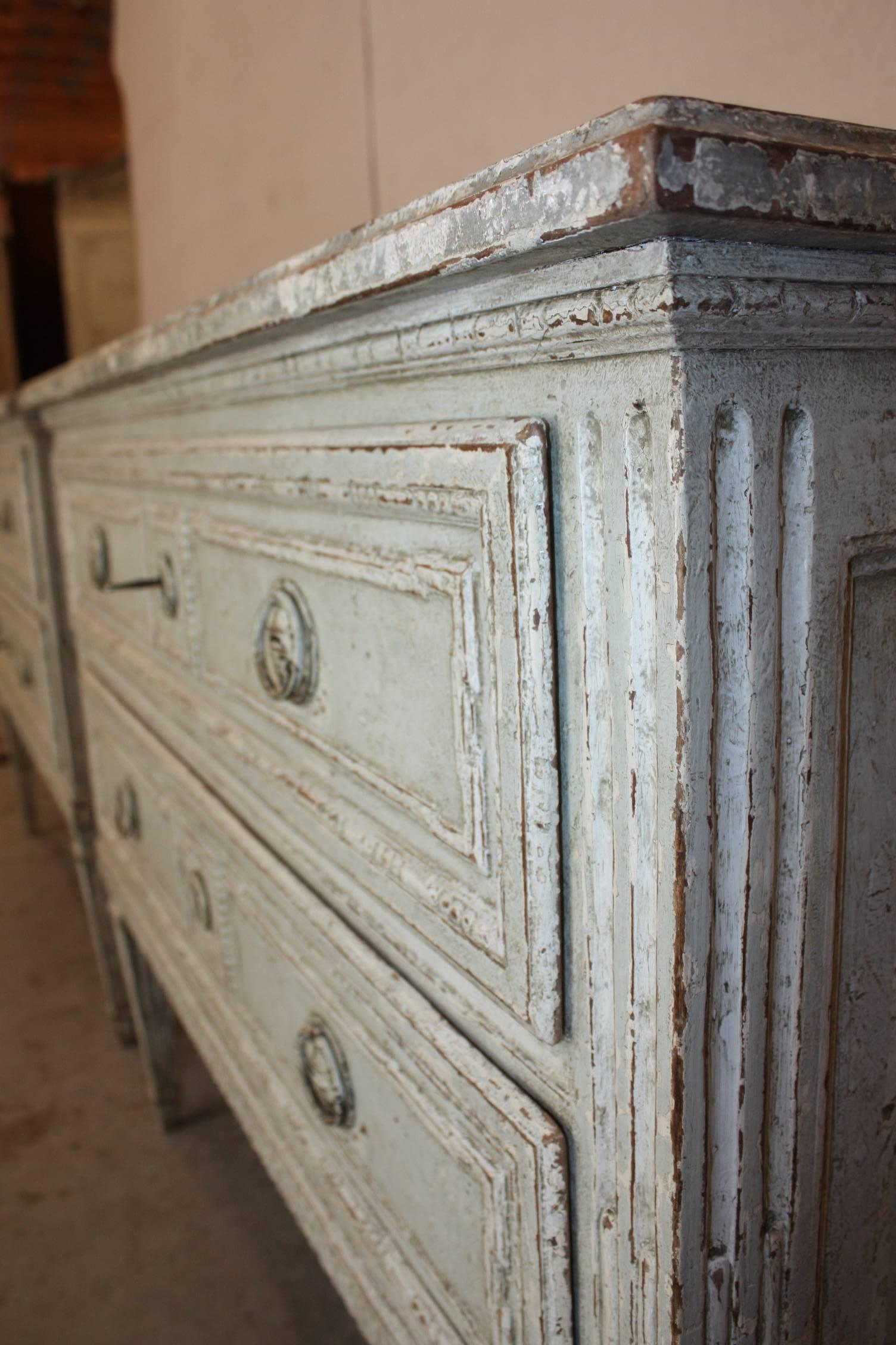 Beautiful pair of French Louis XVI painted commodes chests of drawers, featuring two drawers across the front and a faux marble top. Fine carved wood details. Would make wonderful set of bedside tables.