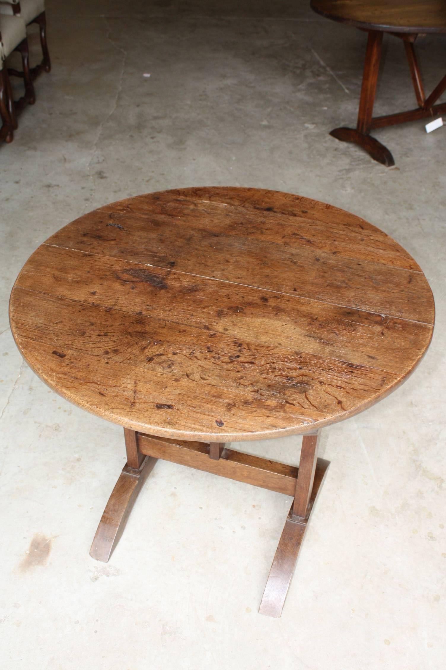 This tilt-top wine tasting table, also known an vendange table in the vineyards of France, is made of solid oak and can be positioned vertically for storage against a wall. Would be great as an end table or a smaller breakfast table. It would also