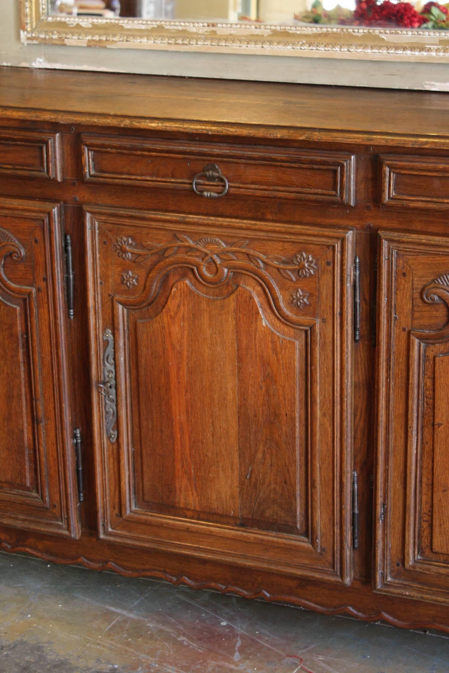 19th century Louis XV carved oak enfilde featuring fine hand-carved details and a rich patina. Five drawers and five large doors that give you plenty of storage. This piece also features unique hardware, beautifully carved shaped apron and is