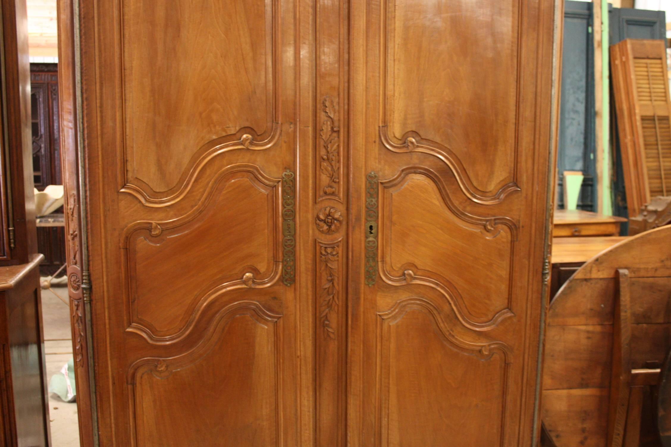 A beautiful armoire in French cherry from the period of Louis XV, who ruled France from 1715-1774. A perfect example from the Lyon region of France. With scalloped apron and carved escargot feet, and original steel lock and hinges.