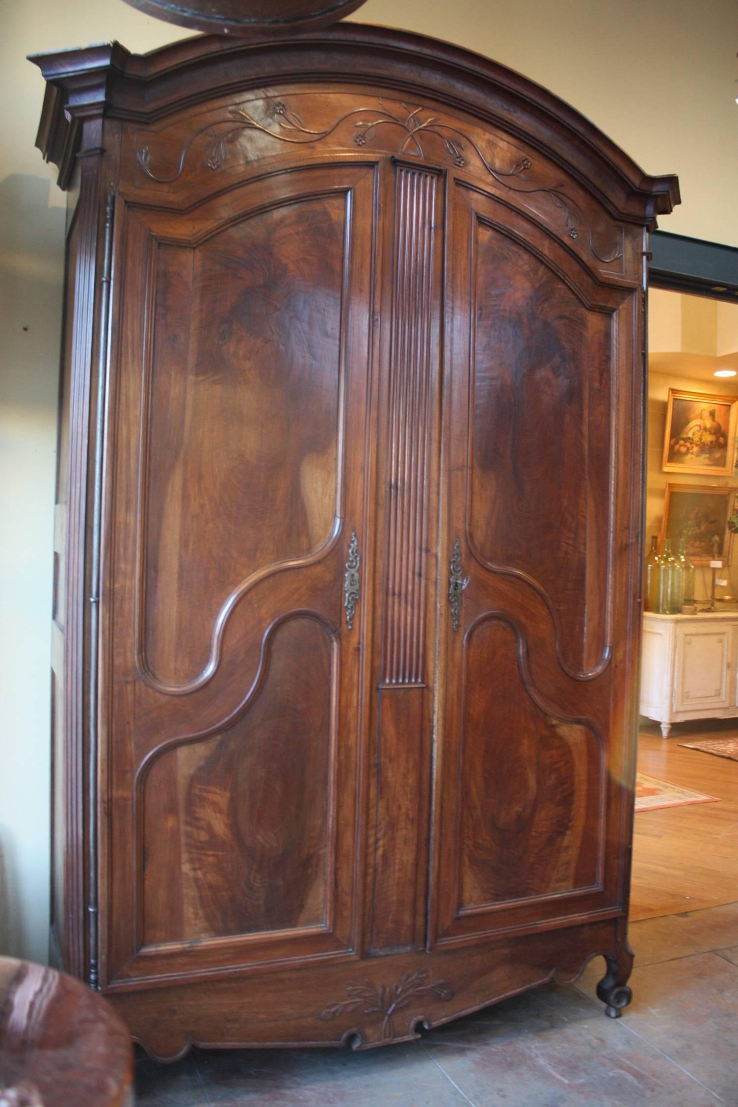 A beautiful armoire in French walnut from the period of Louis XV, who ruled France from 1715-1774. A perfect example from the Lyon region of France. With scalloped apron and carved escargot feet, and original steel lock and hinges.