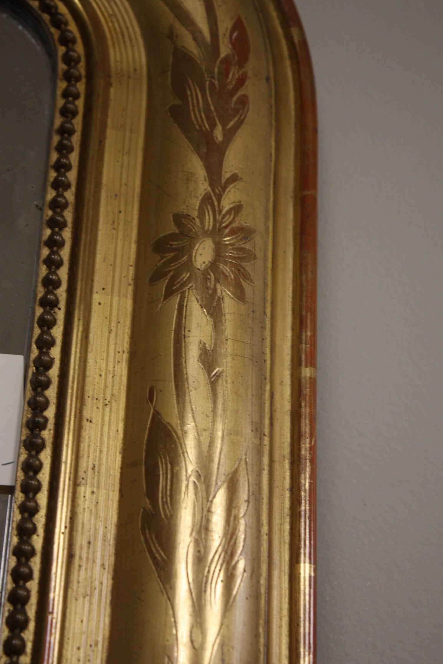 Gilded mirror with light reliefs.