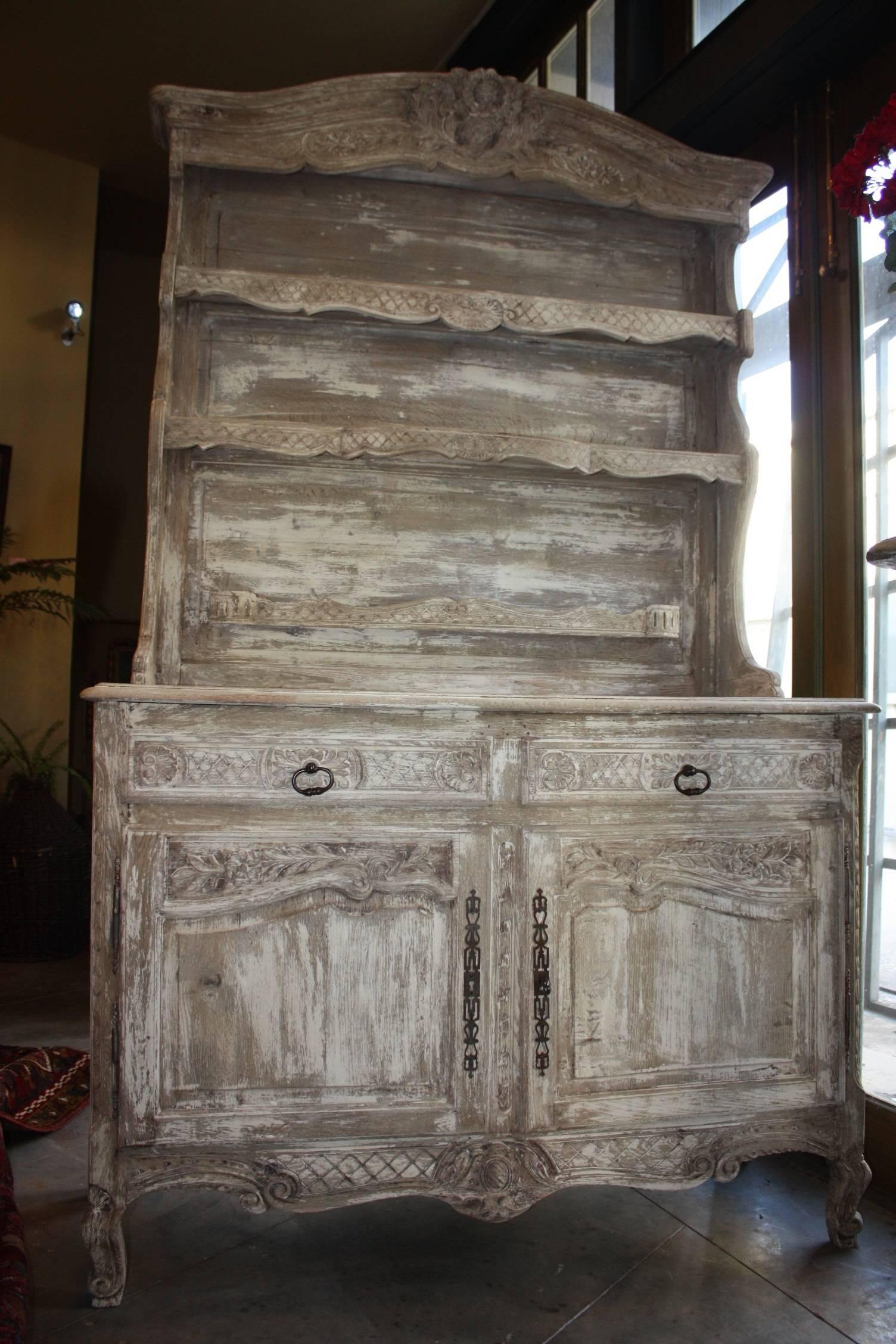 Beautifully washed or bleached French vaisselier/cabinet/bookcase with open shelves at top over a two-door and two-drawer enclosed lower section. This piece is a great size and is a great way to display your pretty collectibles.
