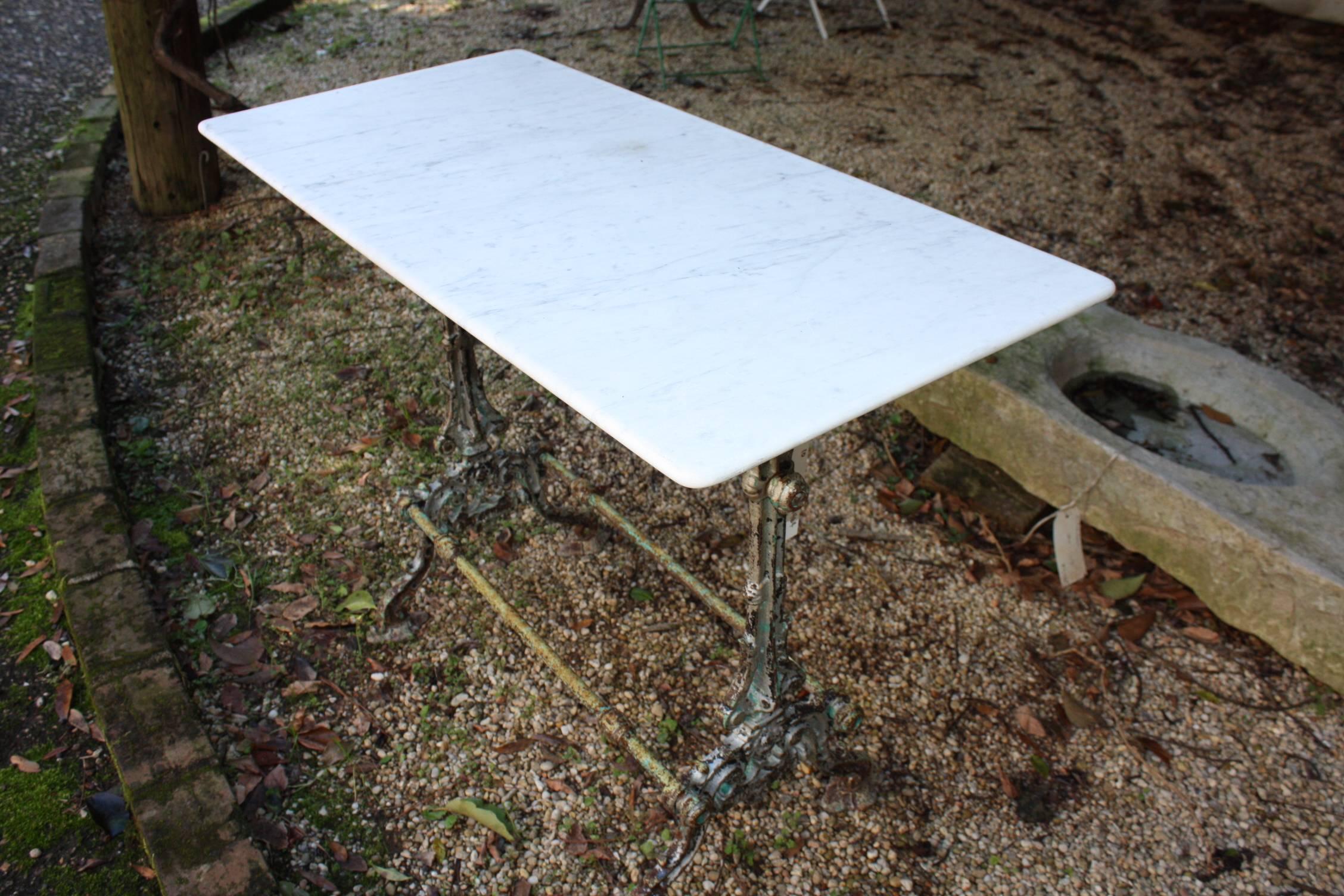 This beautiful bistro table with a two-legged base and original white marble top makes a great dining table or kitchen work table. The base is very sturdy with two cast iron legs and stretchers and the marble is in great condition.