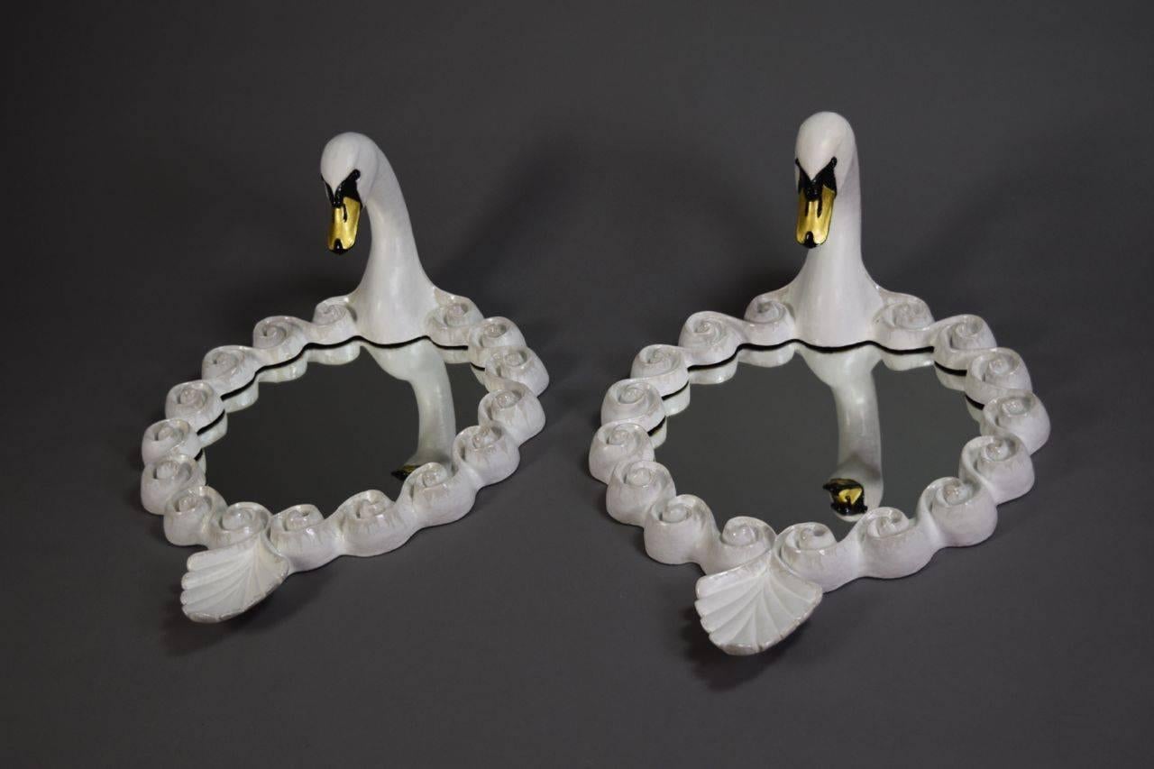 This unique pair of mirrors has a wave molded border with a swan crest and a swan tail finial. The male and female swans look down into the mirror as if gazing into the water.

English ceramicist Gail Dooley works out of a studio in Yorkshire. Her